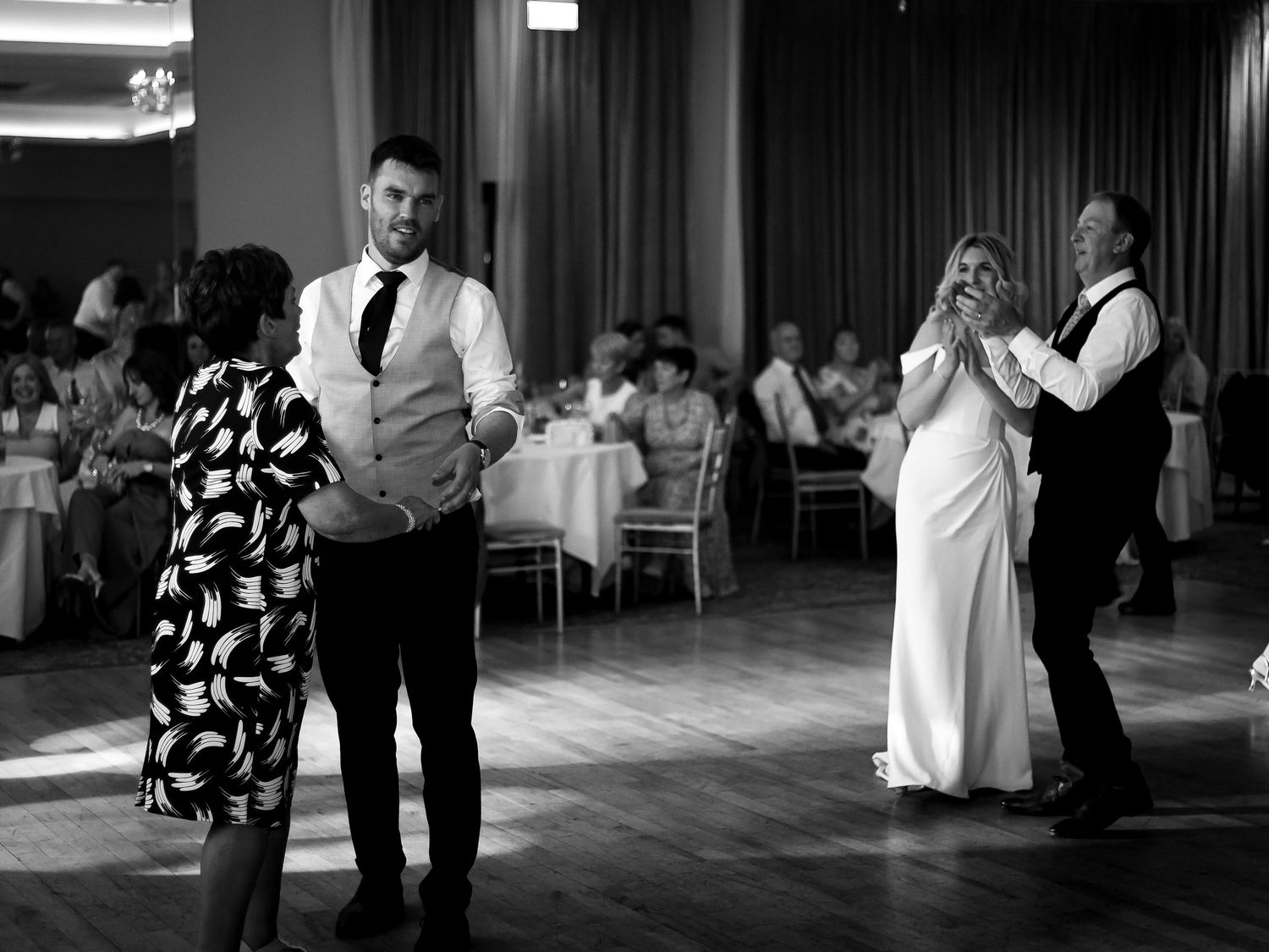 Black and white photos of couples dancing and embracing at an indoor wedding reception.