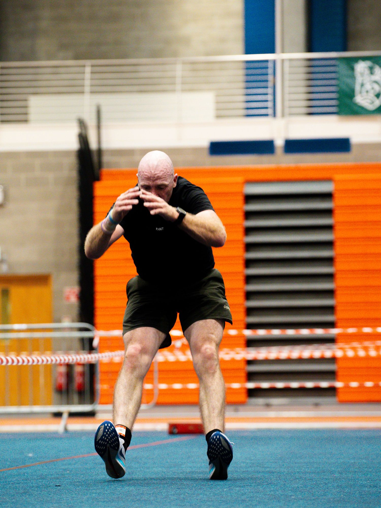 A sequence of four action shots showing an athlete performing a high jump technique at an indoor track facility.