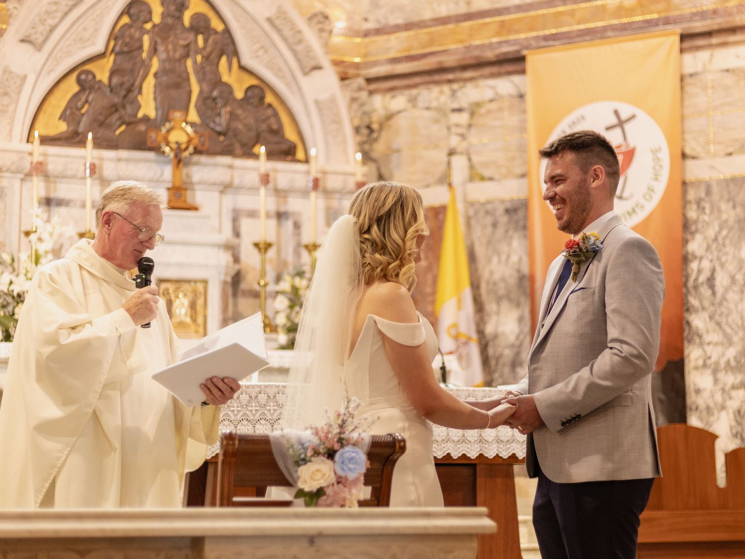 Bride and groom share their first dance together in an ornate church sanctuary during their wedding ceremony.