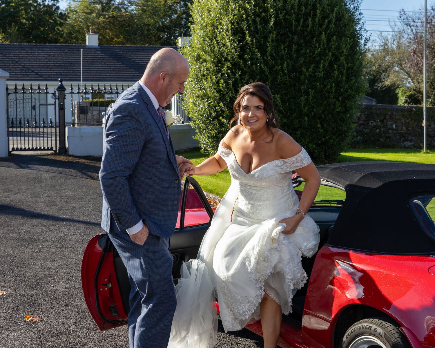 Red sports car decorated for wedding transportation.