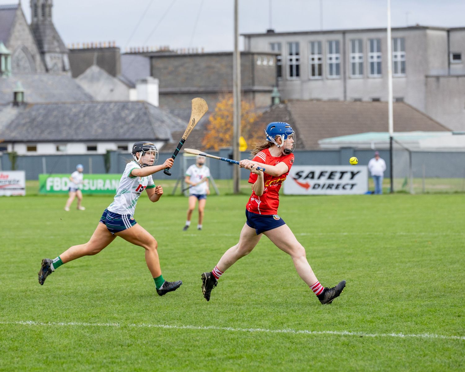 Camogie players dive for the ball in a sequence of action shots showing a dramatic play on the field.