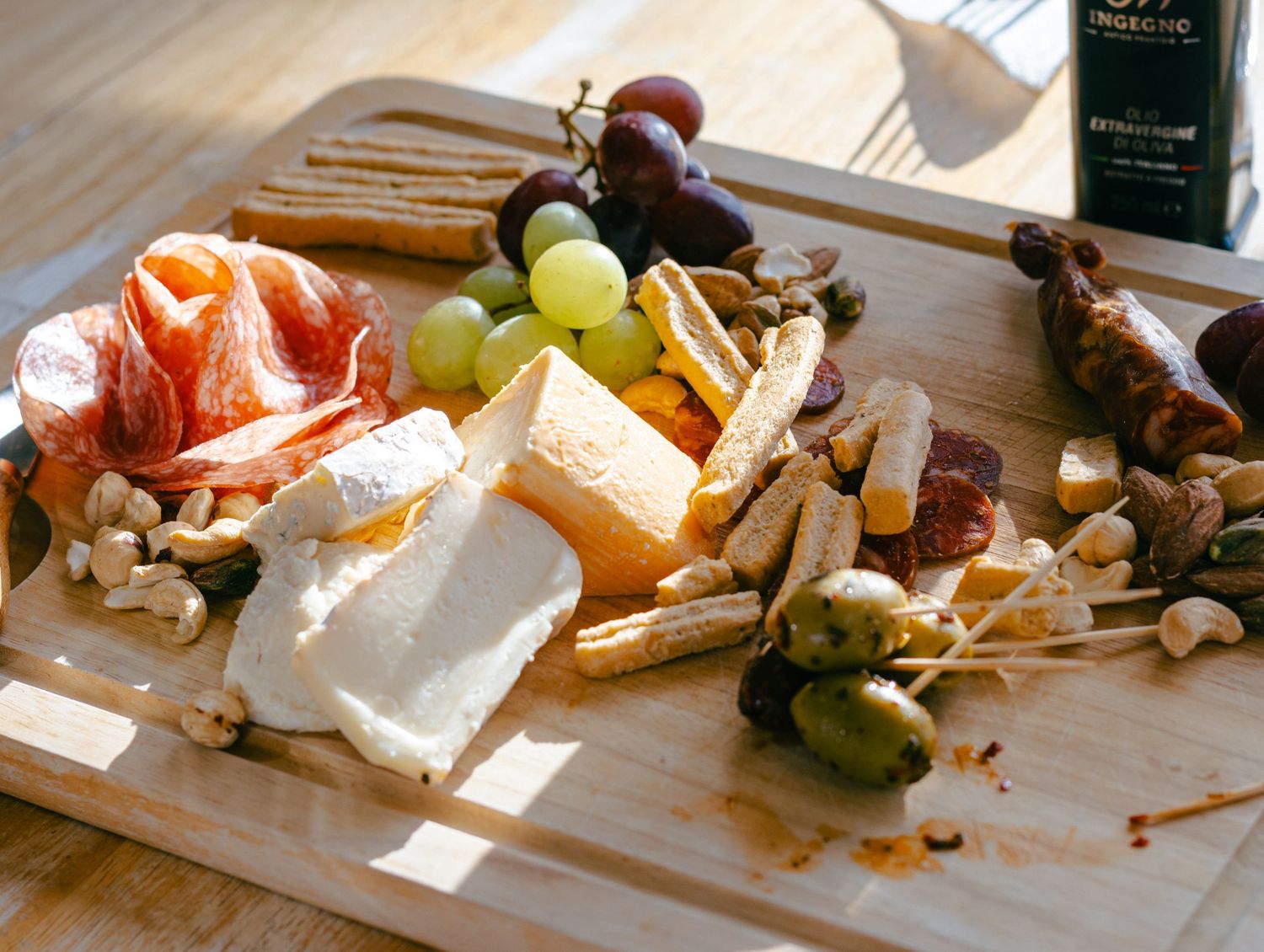 A rustic wooden charcuterie board with assorted meats, cheeses, fruits, and nuts arranged in an appetizing display.