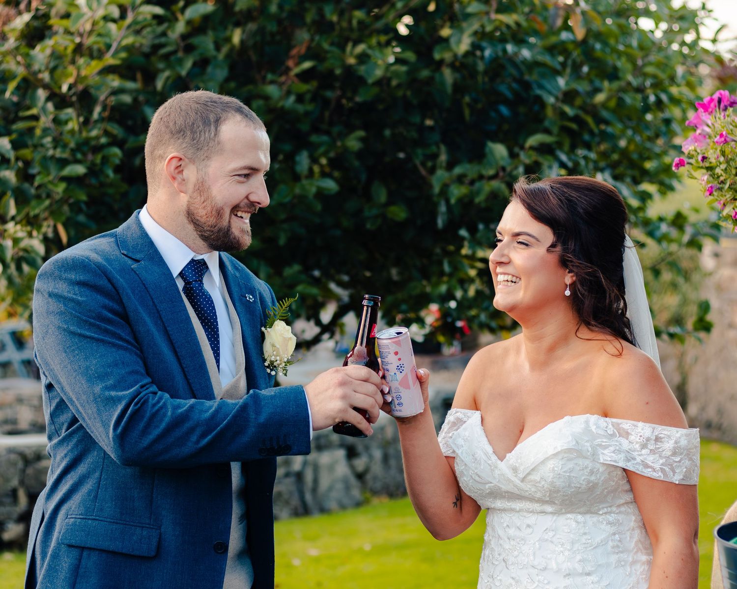 Wedding couple shares intimate moment in garden setting during golden hour.