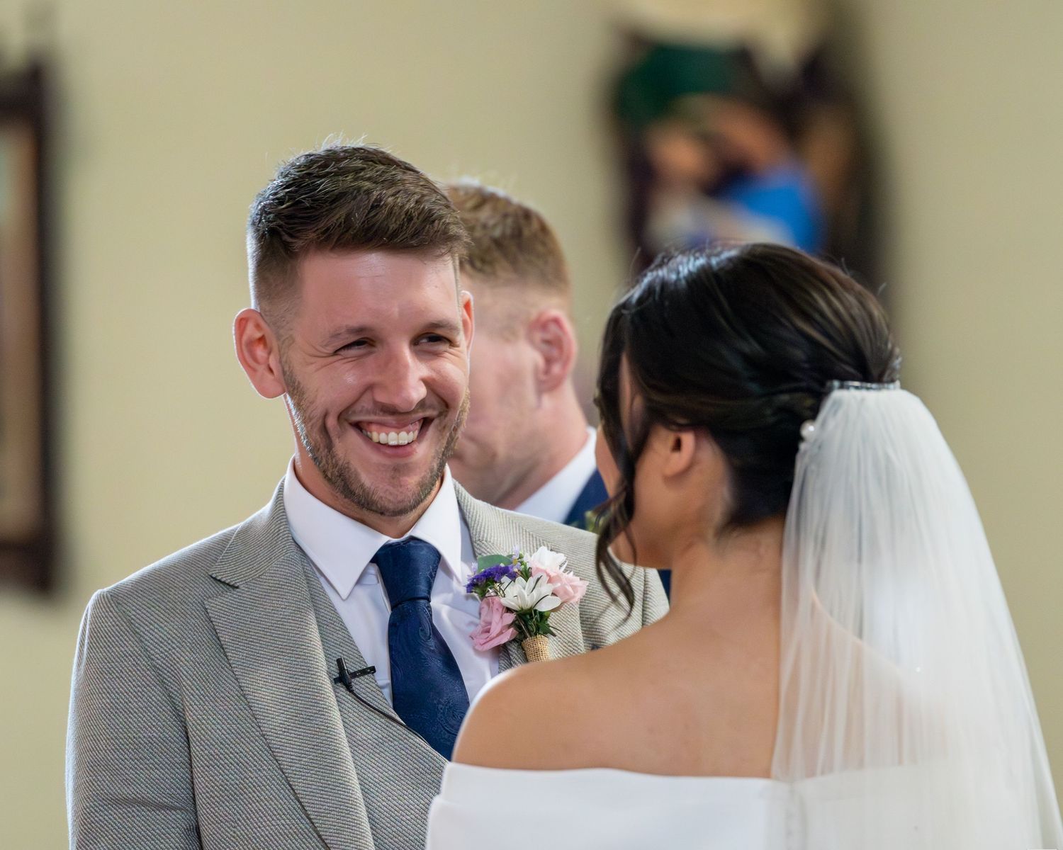 A wedding couple shares a joyful moment during their celebration with guests looking on.