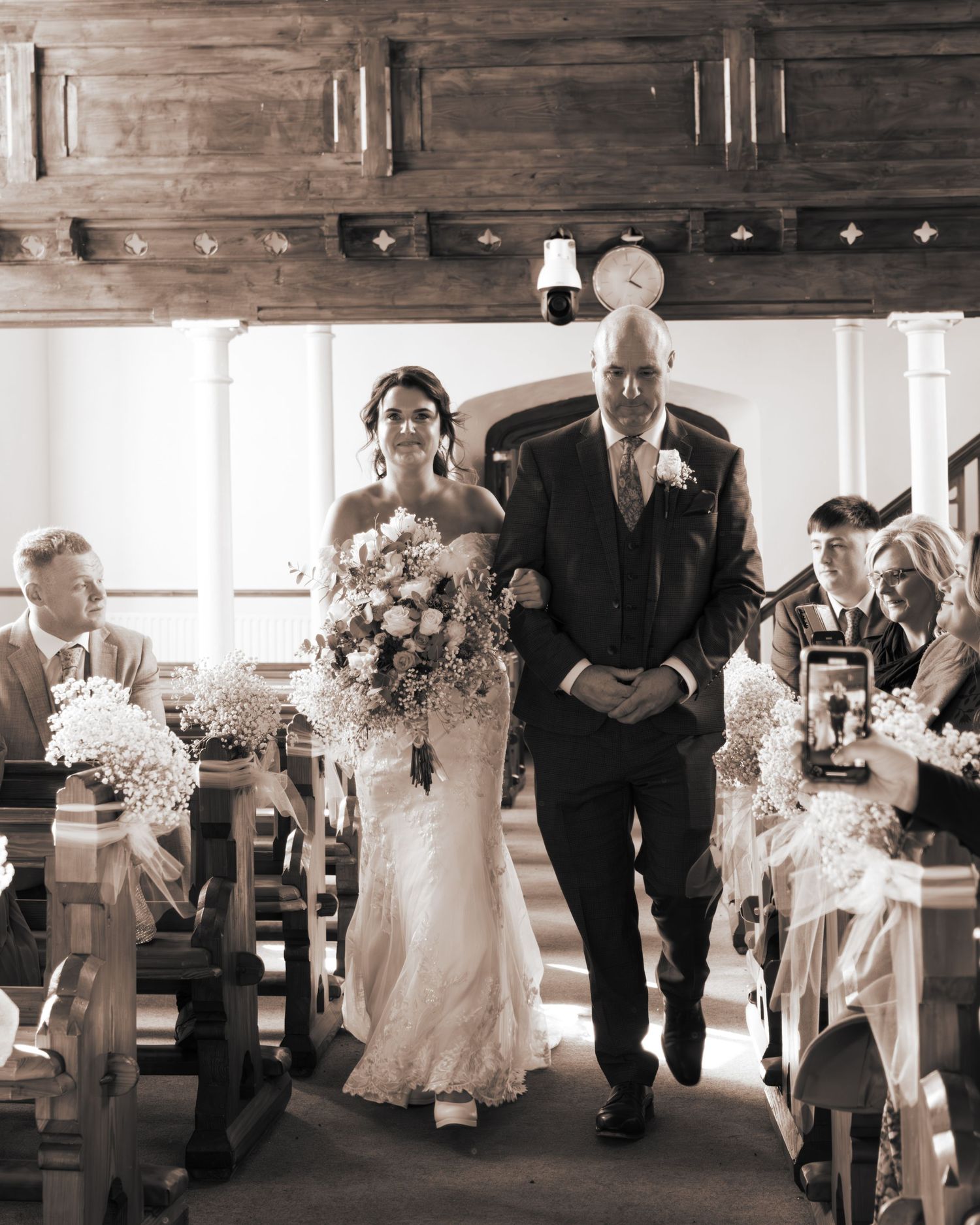 Wedding reception entrance with rustic wooden ceiling beams.