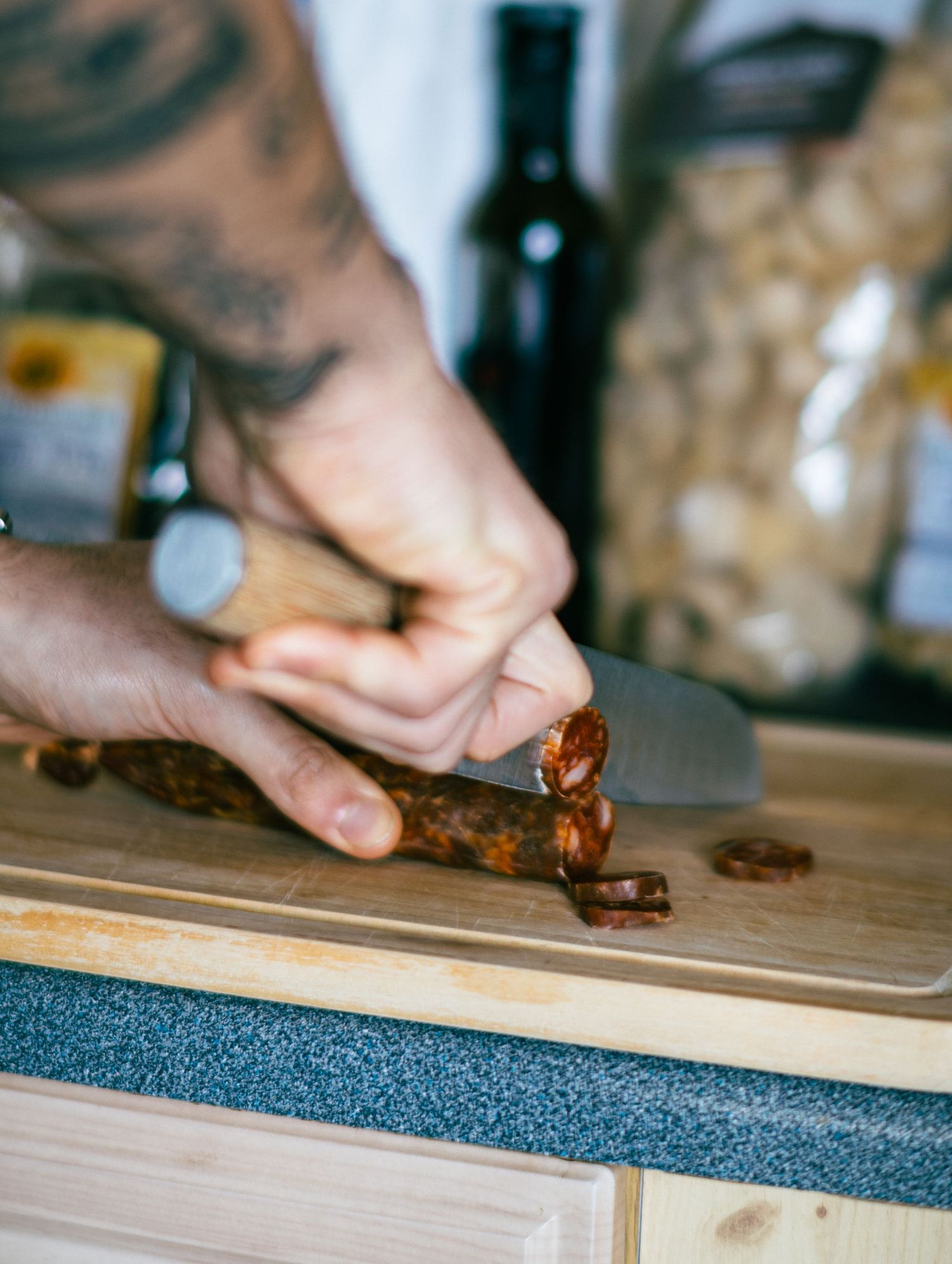 Close-up sequence of hands slicing dark chocolate on a wooden cutting board.