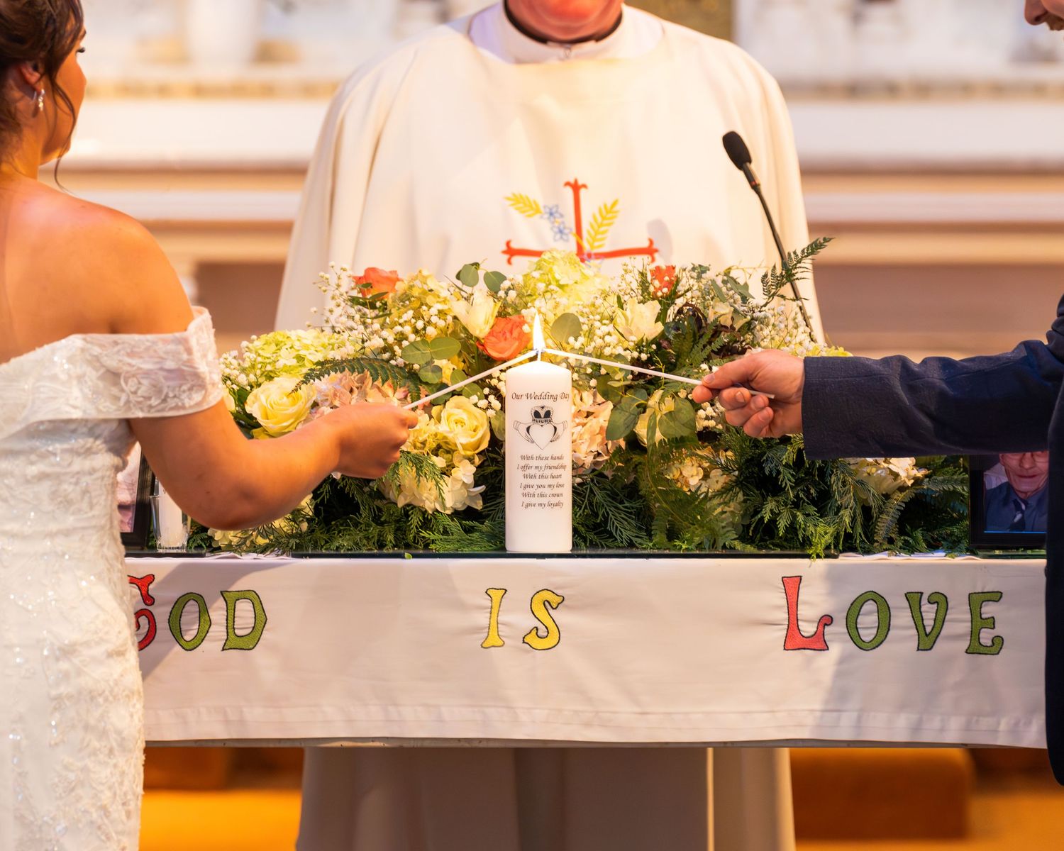 Church altar decorated with flowers and 'GOD IS LOVE' text for wedding ceremony.