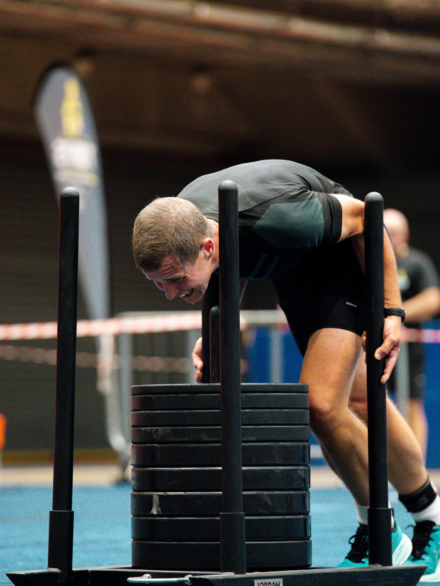 A sequence of photos showing someone performing a plank exercise with increasing stacks of weight plates on their back.