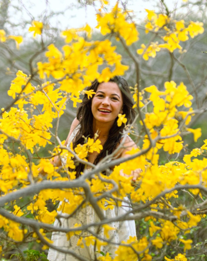 “Arikok National Park Aruba photoshoot with a woman surrounded by bright yellow kibrahacha flowers during golden season.”