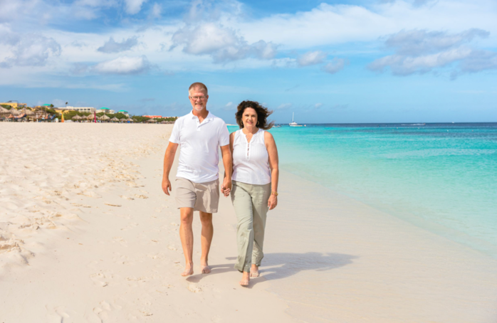 Aruba couples beach photography, candid walking portrait on white sand and turquoise water.