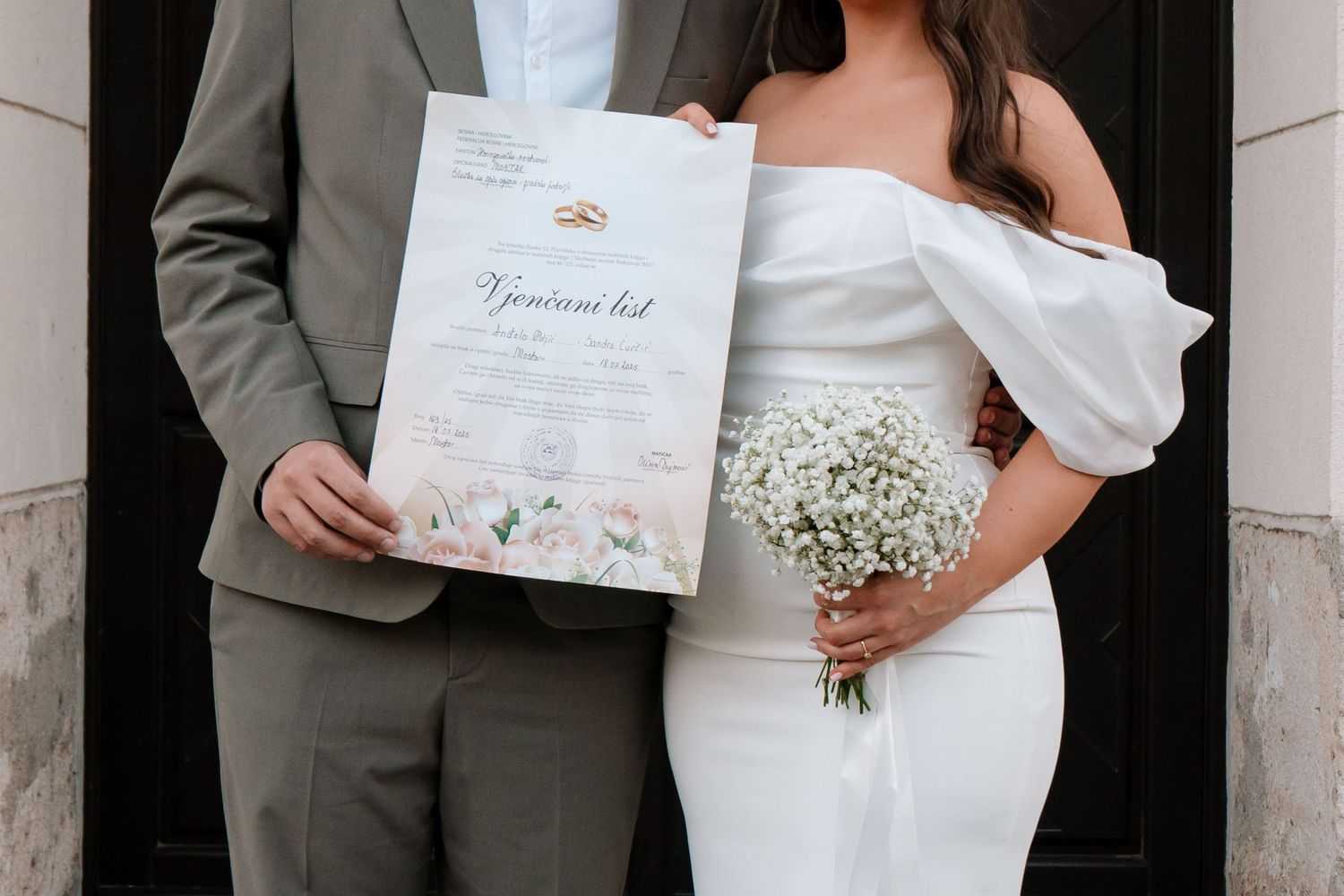 Mladenci drže vjenčani certifikat nakon obreda, Mostar