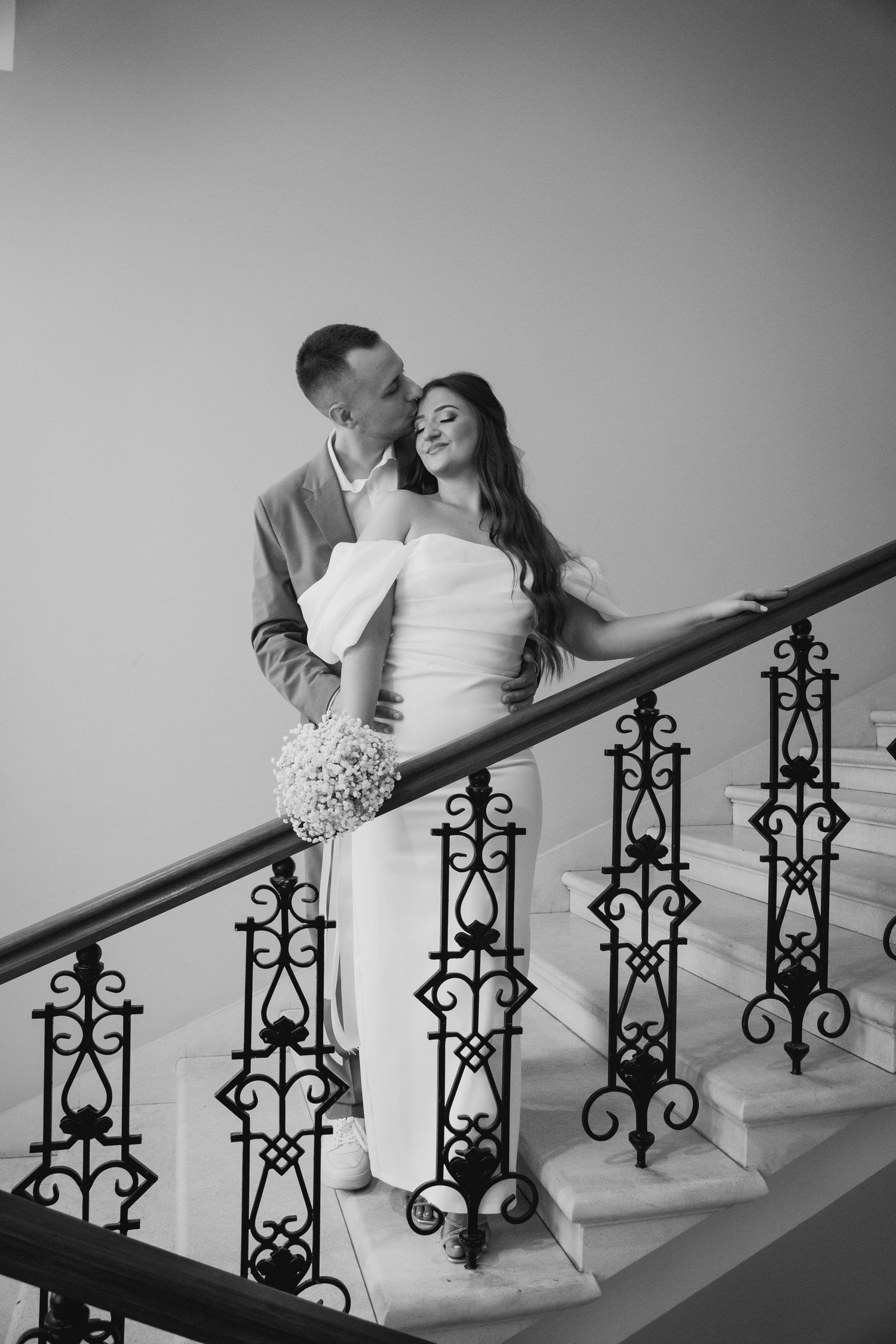 Mladenci zagrljeni na stepenicama, crno-bijela fotografija vjenčanja Mostar