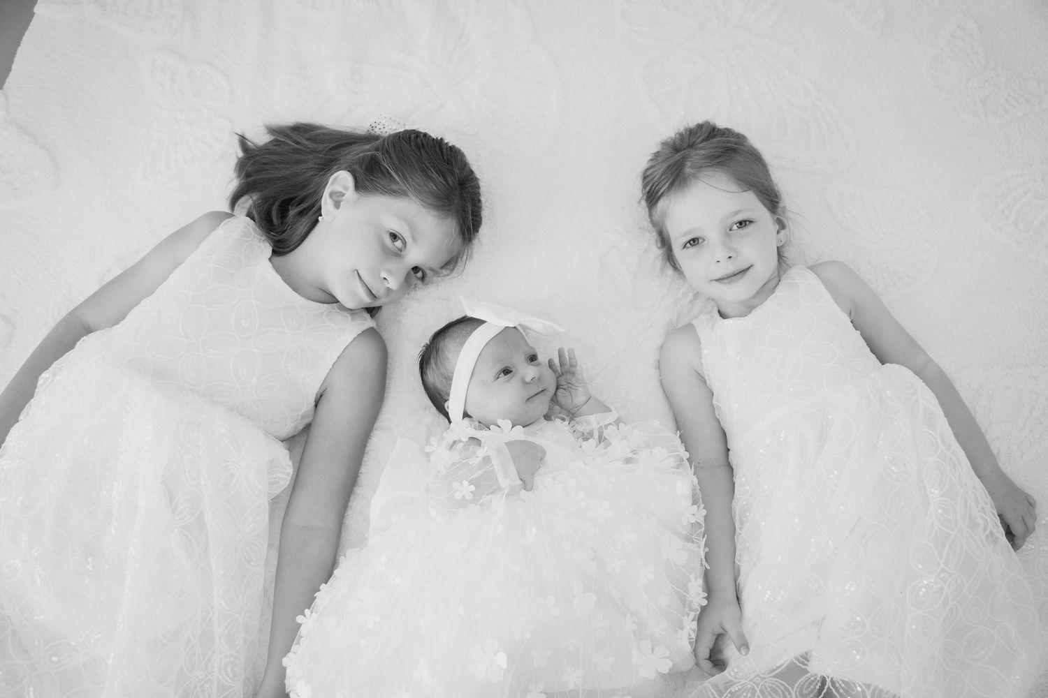 Sestre leže pored novorođene bebe, obiteljska fotografija Mostar