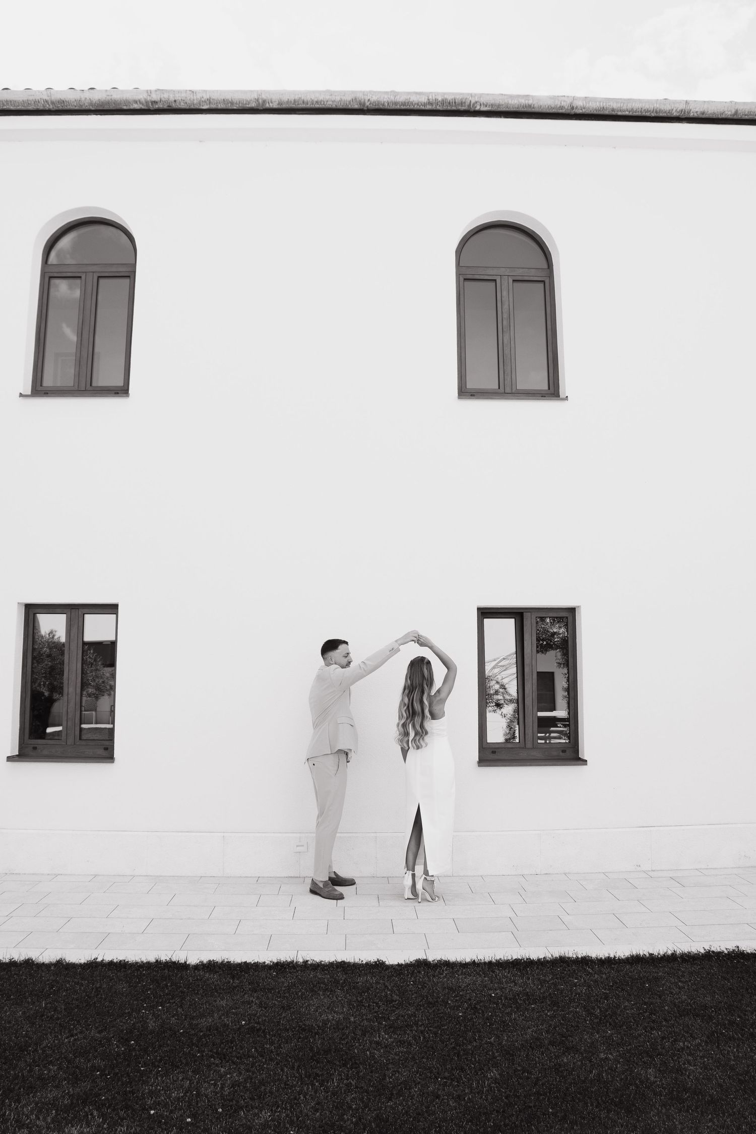Mladenci ispred bijele zgrade s prozorima, vjenčanje Mostar