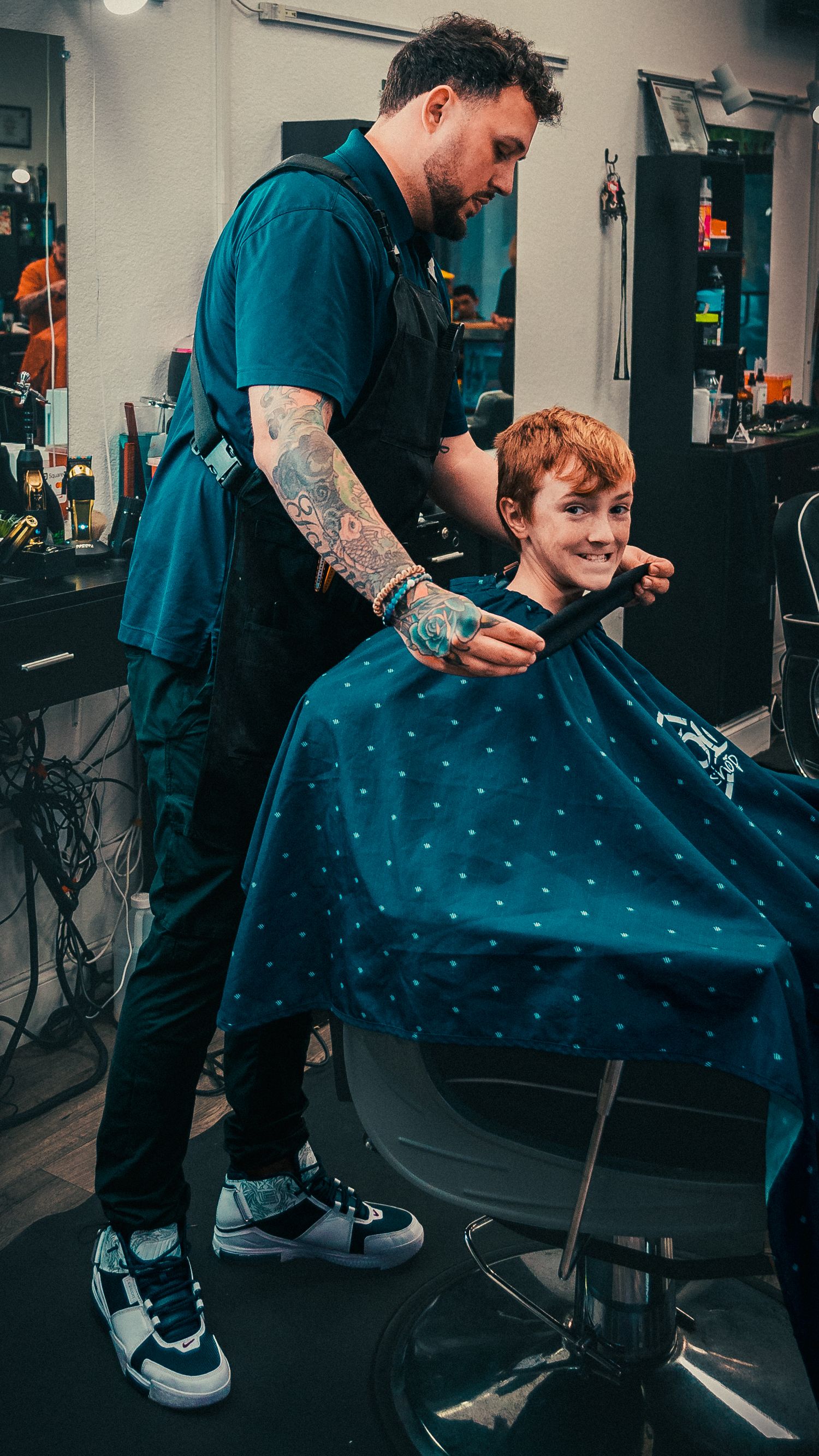 Modern barbershop interior with polka dot cape and styling stations.