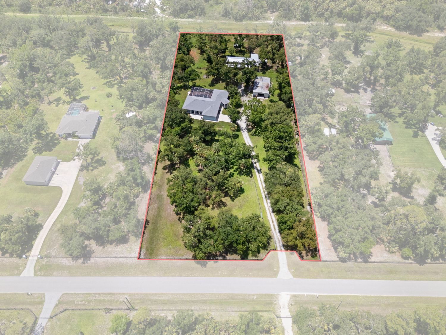 Aerial view of a residential property surrounded by lush greenery and trees.