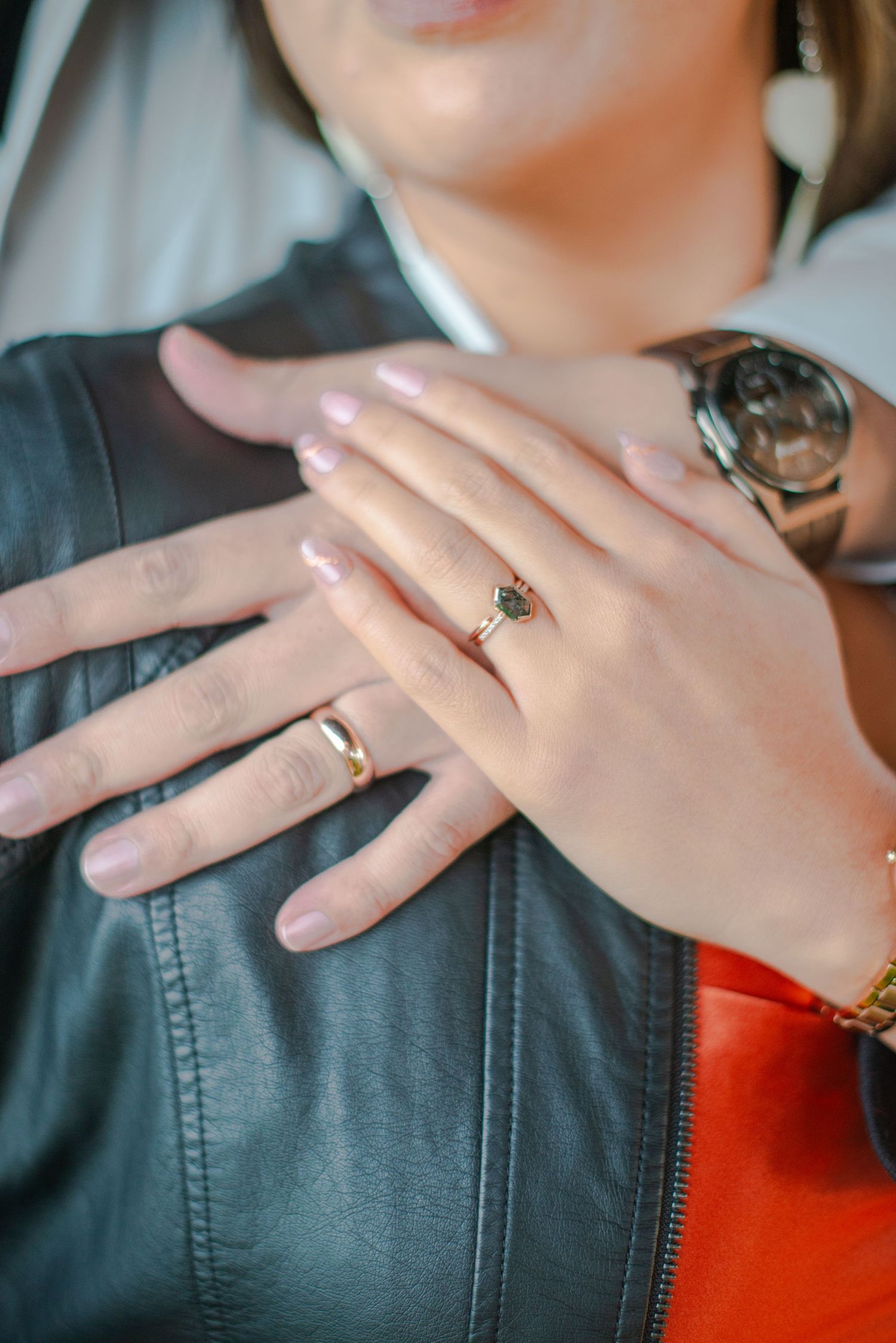 Close-up of hands displaying an emerald engagement ring against a red dress. Knoxville Couple Photographer