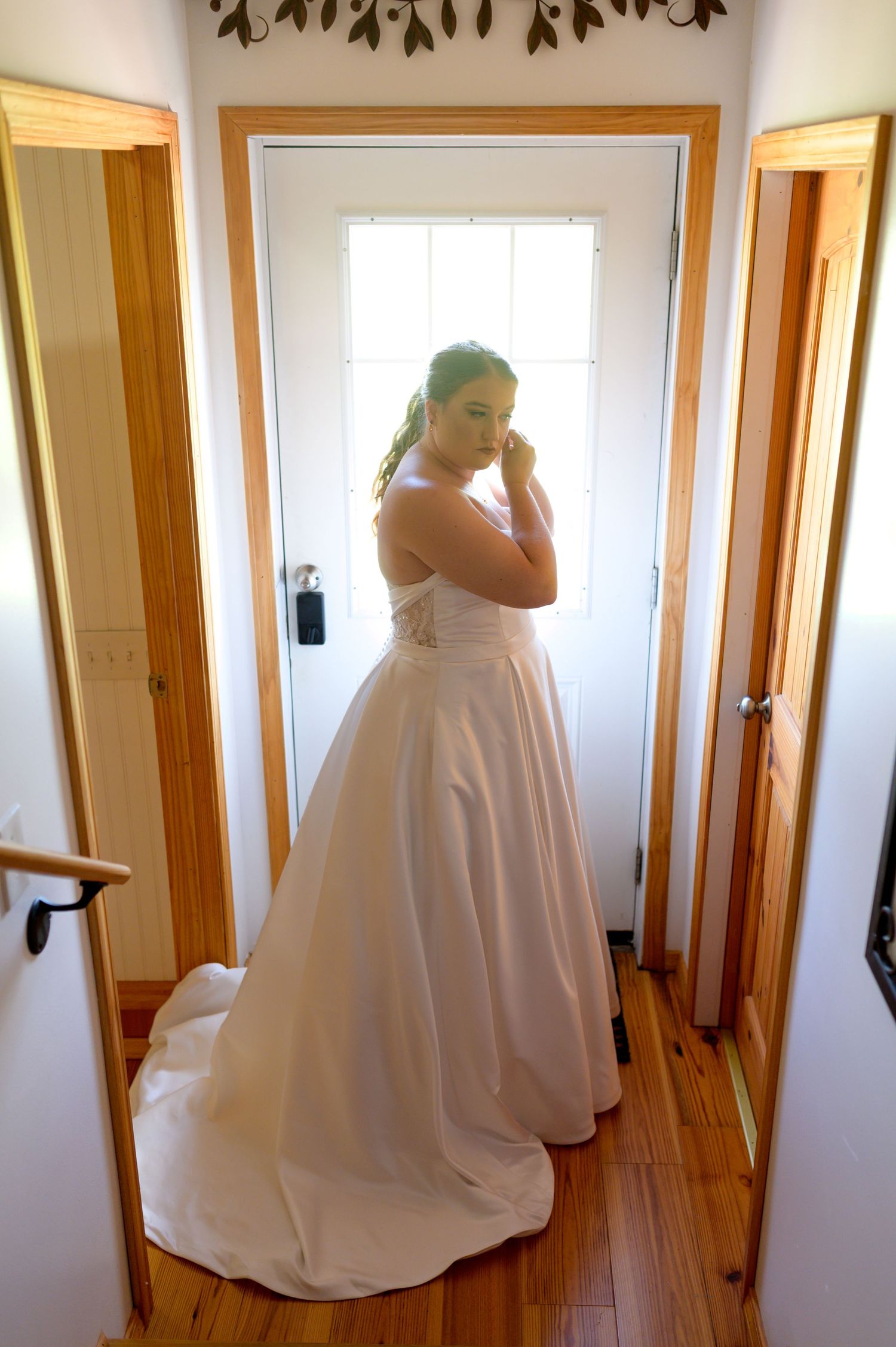 A flowing white wedding dress is shown in a series of frames against wooden door frames and white walls. Knoxville Wedding Photographer