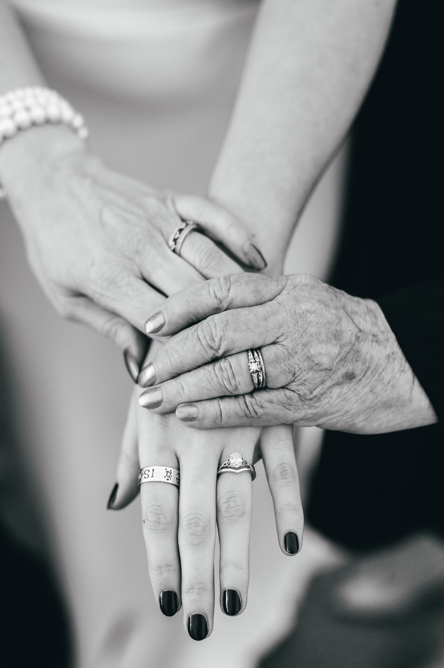 A black and white close-up of hands showing wedding rings and generations of jewelry. Knoxville Wedding Photographer