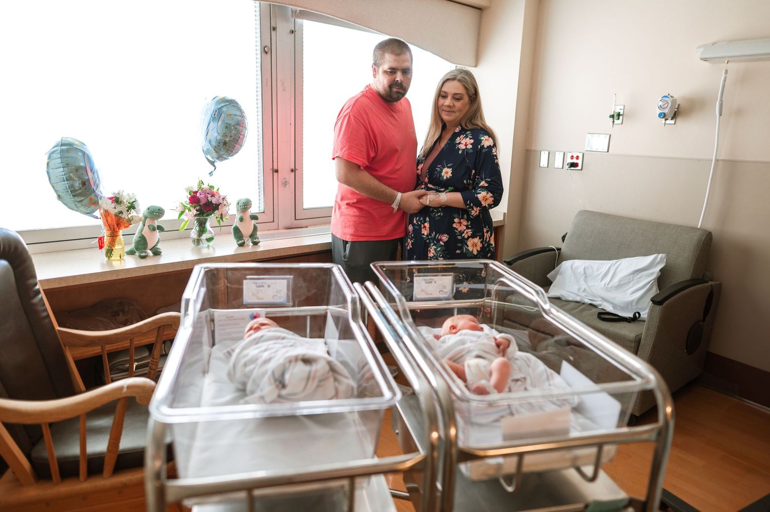 Hospital room with family members gathered around newborn's bassinet. Knoxville Newborn Photographer UT Medical Center