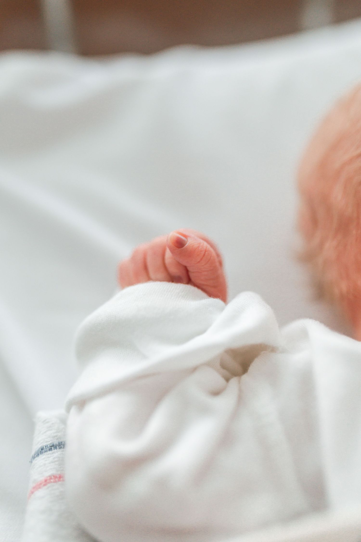 Close-up of white hospital blanket with blue and pink stripes. Knoxville Newborn Photographer UT Medical Center
