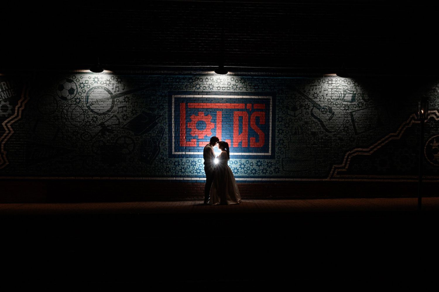 Dark nighttime exterior view of an illuminated venue entrance. Knoxville Wedding Photographer. Lolas Industrial Venue