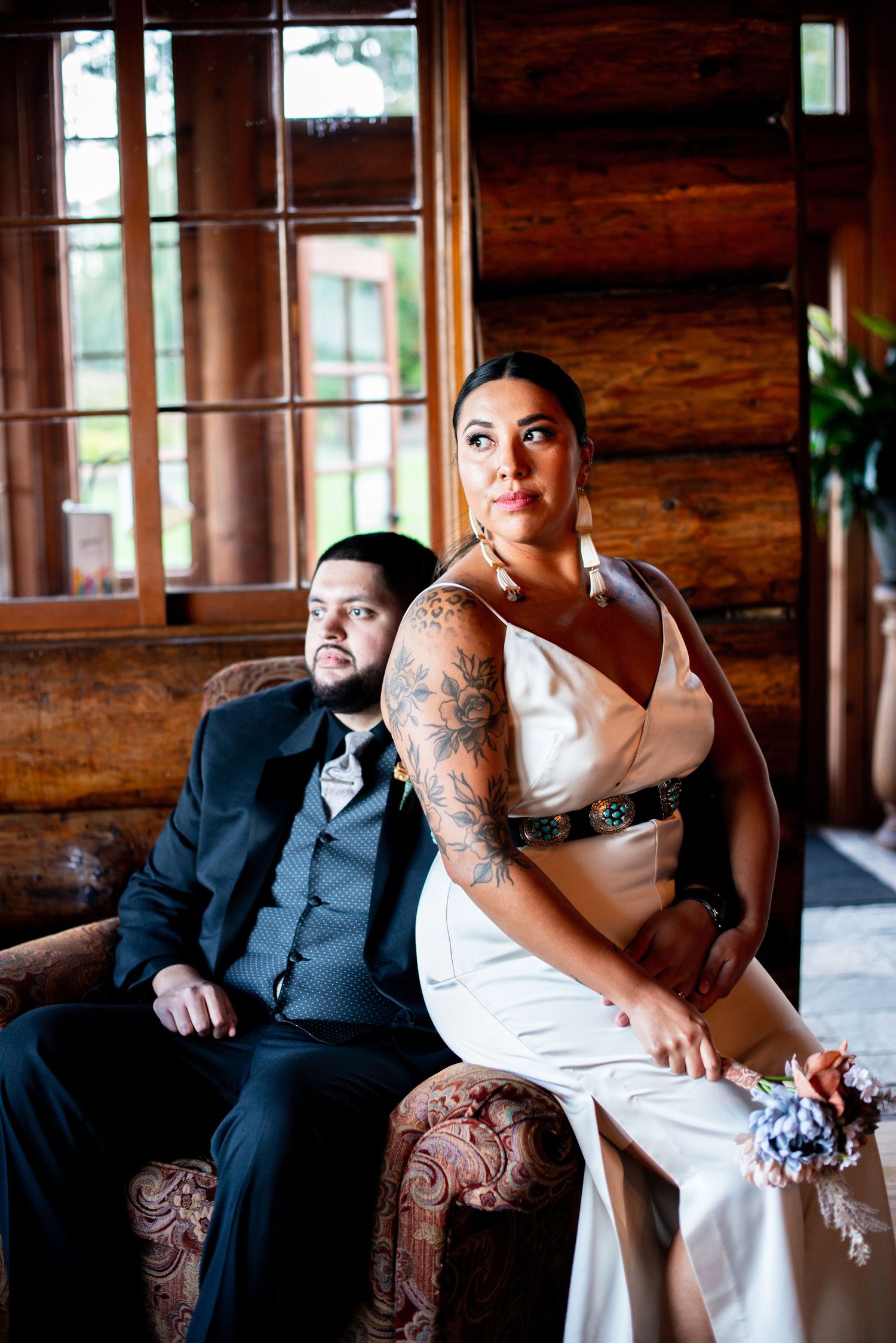 Wedding couple poses on vintage furniture in a rustic wooden room. Knoxville Wedding Photographer