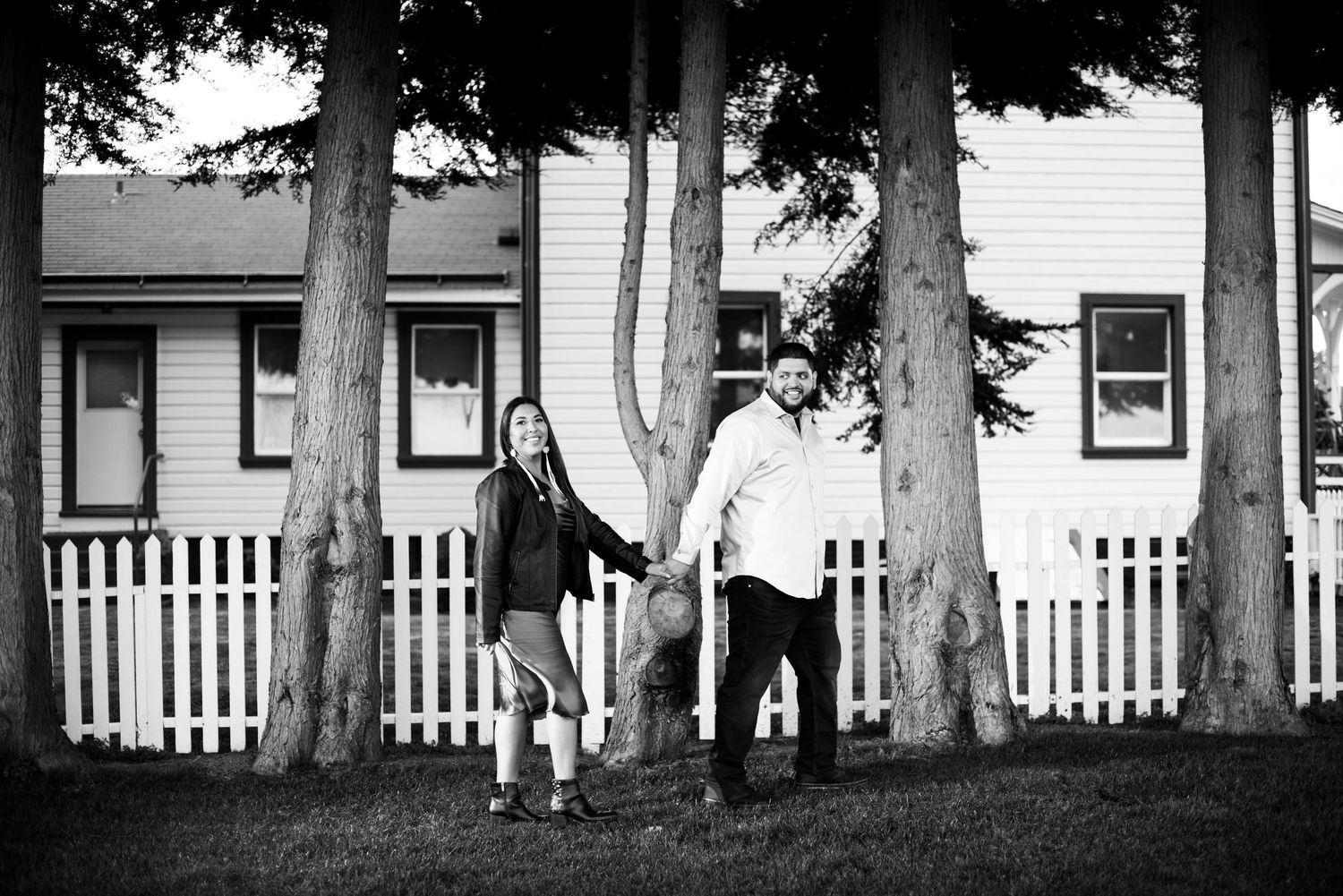 Black and white architectural photo of trees and white picket fence near historic buildings. Knoxville Couple Photographer