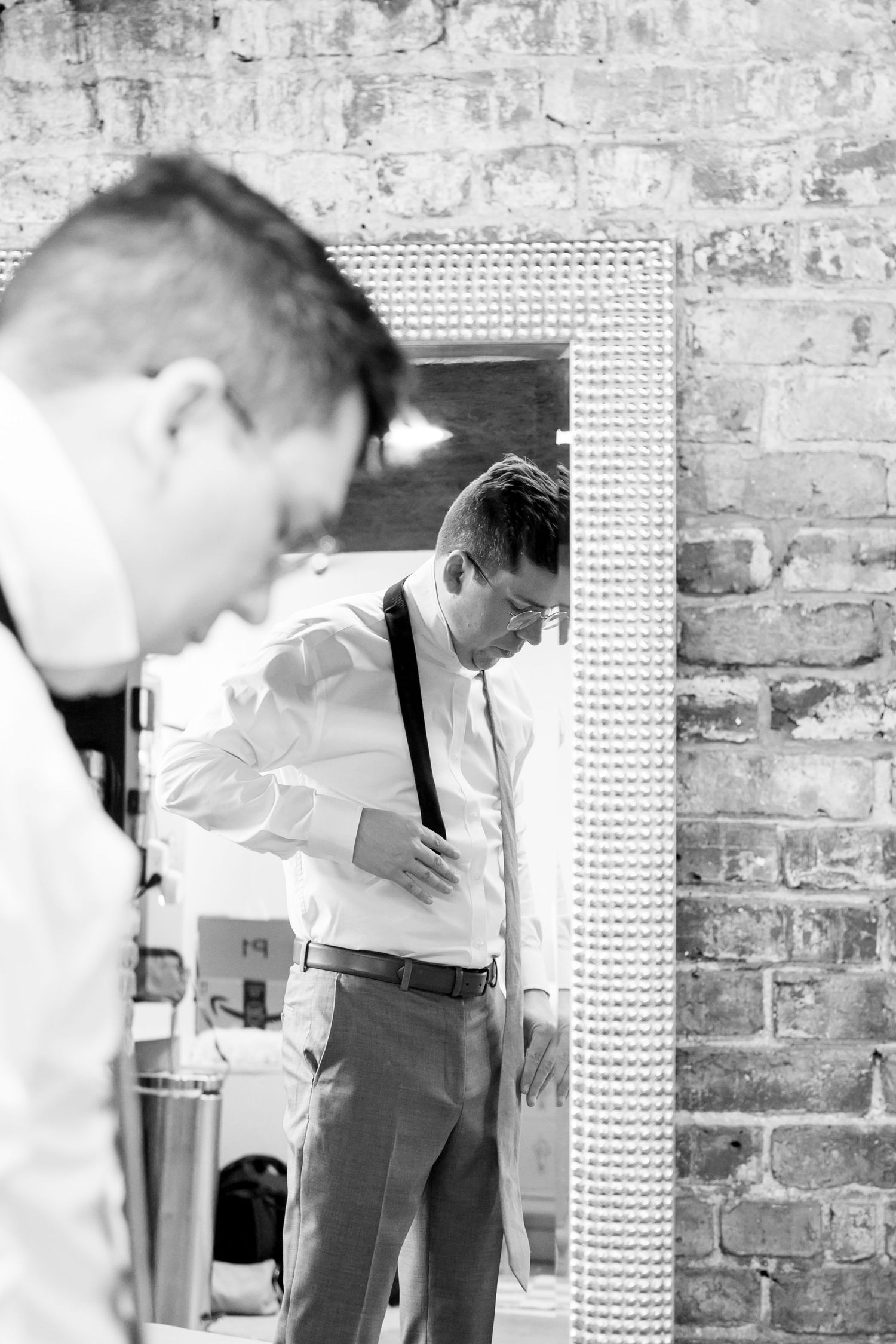 Black and white photos show preparations before a wedding ceremony against a brick wall backdrop. Knoxville Wedding Photographer
