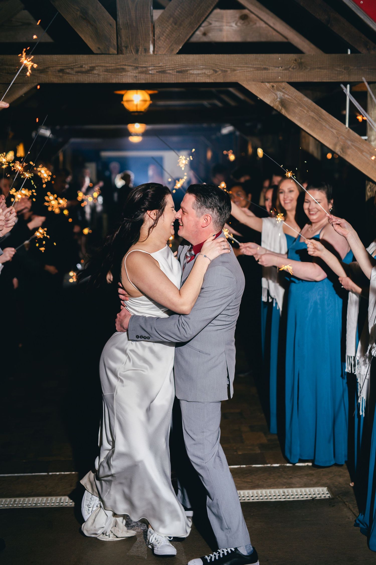 A couple shares an intimate dance moment in a rustic barn venue with wooden beams. Knoxville Wedding Photographer