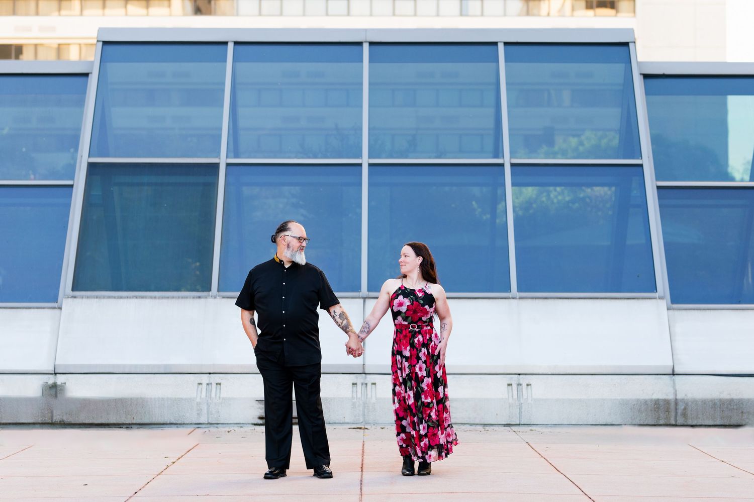 A couple standing against a modern architectural backdrop in an urban setting. Knoxville Couple Photographer