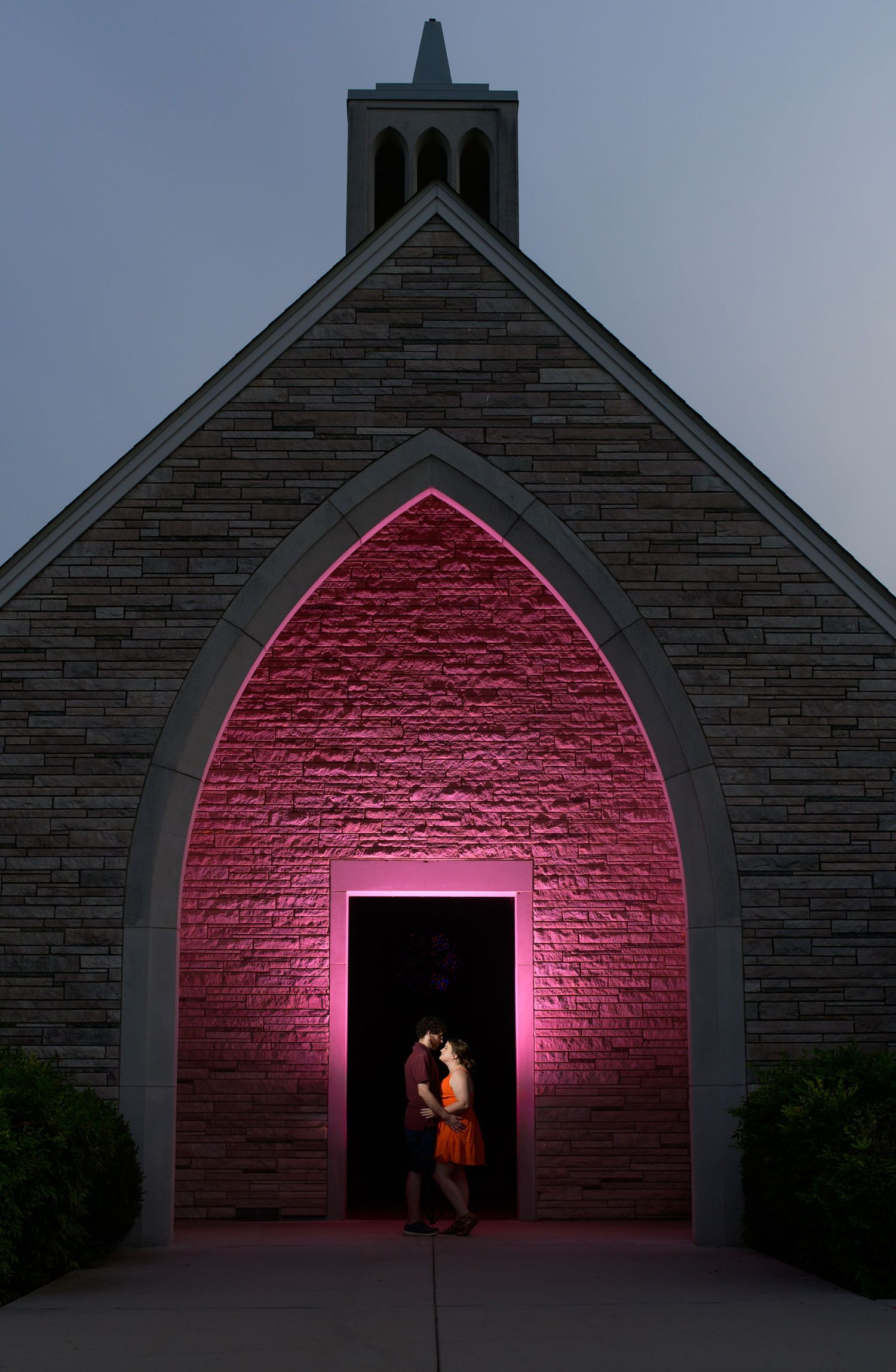 A sequence showing a dark stone archway gradually illuminated by pink light, creating a dramatic architectural lighting effect.