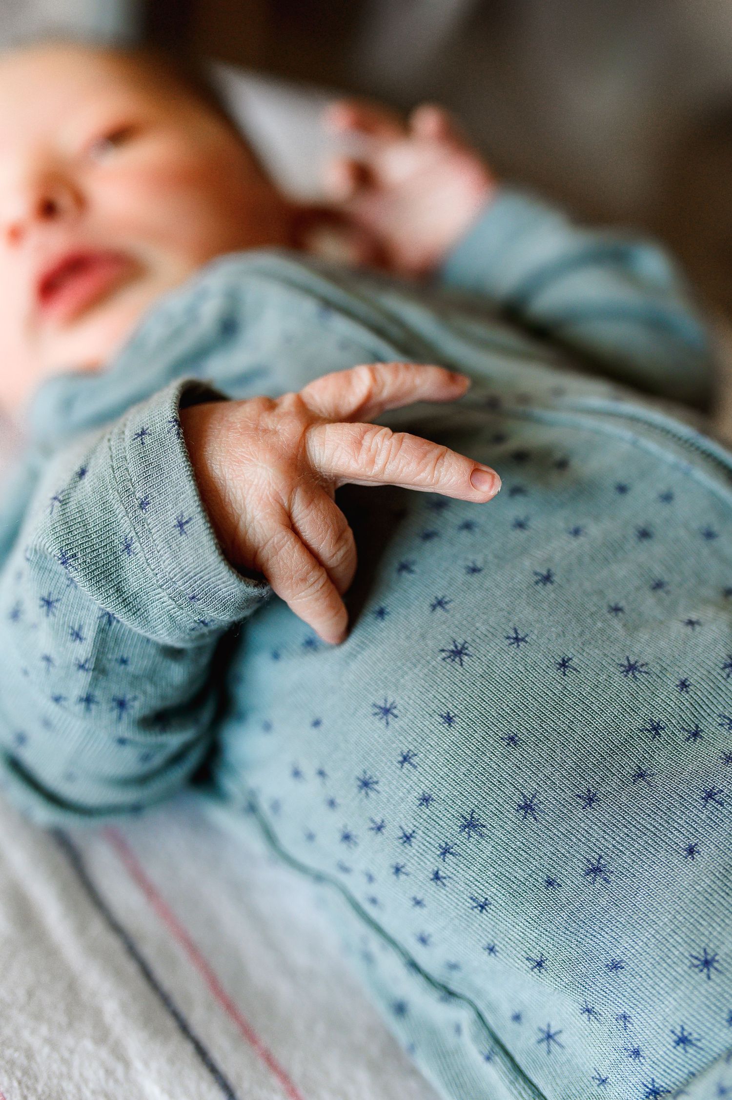 Close-up of tiny hands grasping a soft blue star-patterned fabric. Knoxville Newborn Photographer UT Medical Center