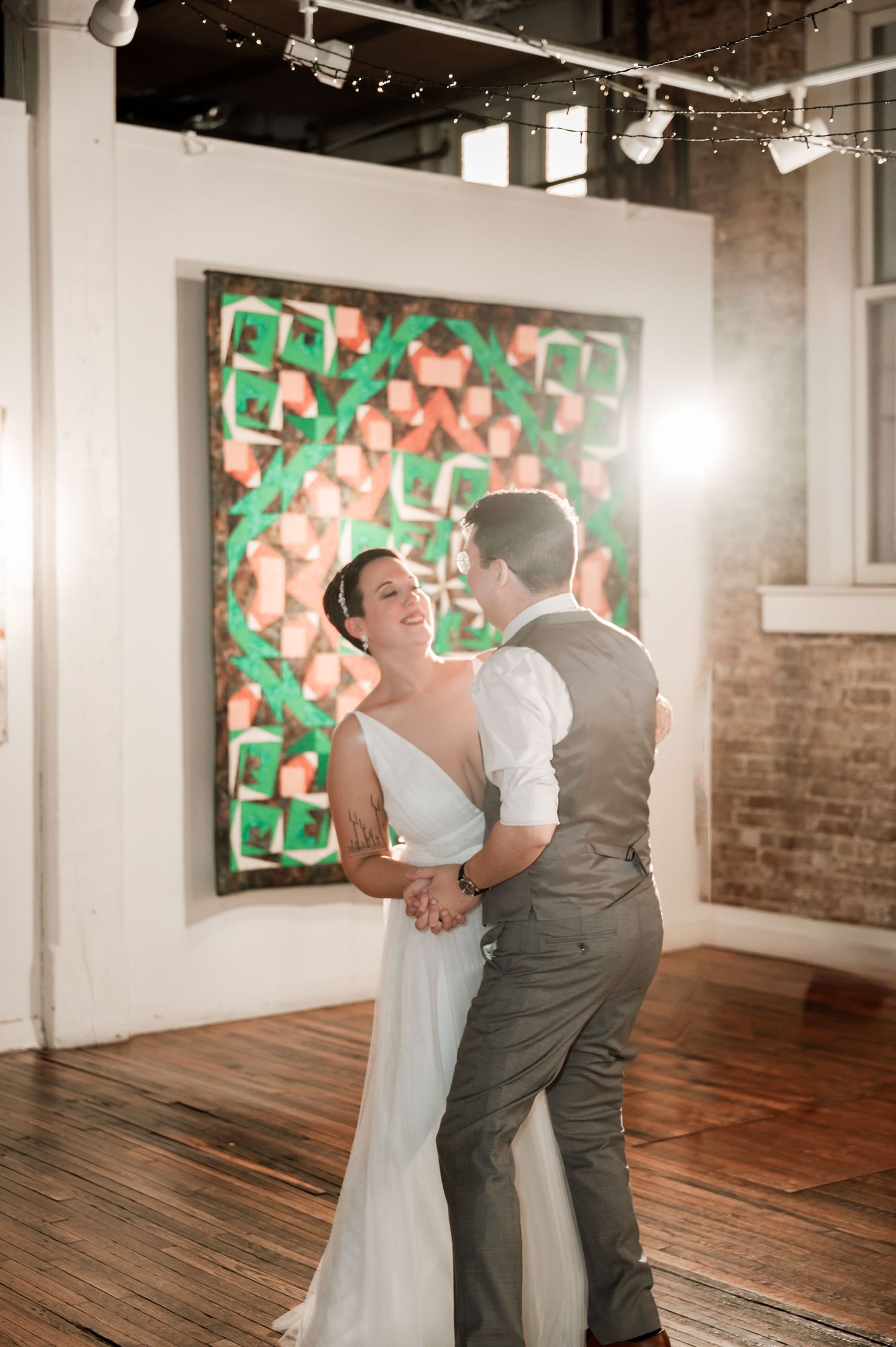 Wedding dance captured in sequence inside rustic venue with exposed brick walls and hardwood floors. Knoxville Wedding Photographer