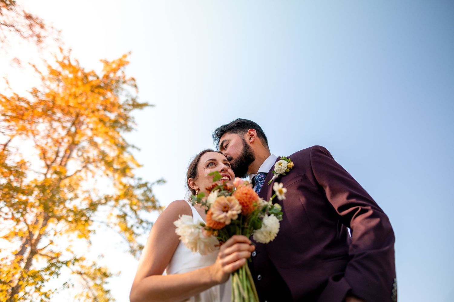 Autumn wedding portraits with orange foliage against bright blue sky. Knoxville Wedding Photographer