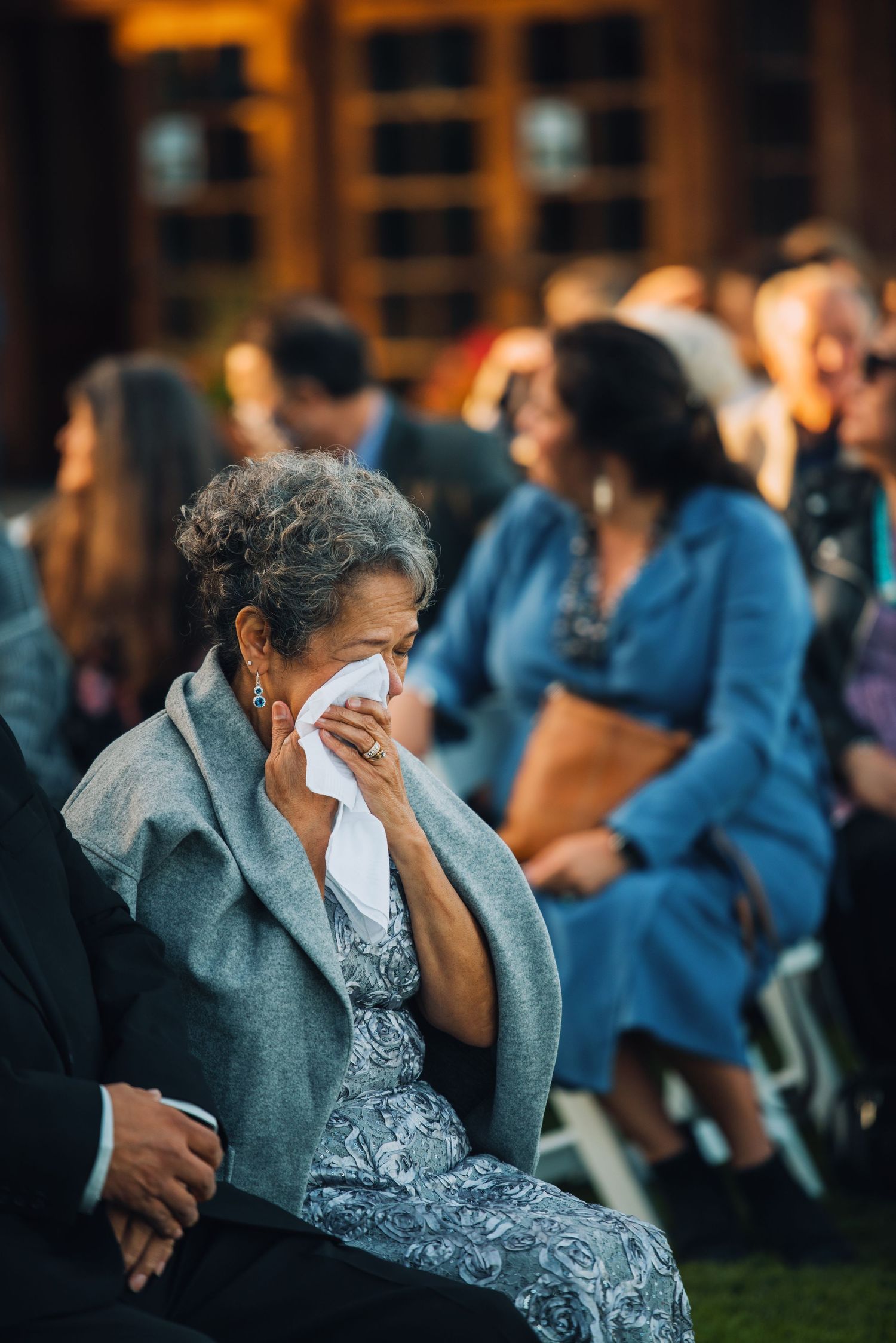An emotional guest dabs tears with tissue during outdoor wedding ceremony. Knoxville Wedding Photographer