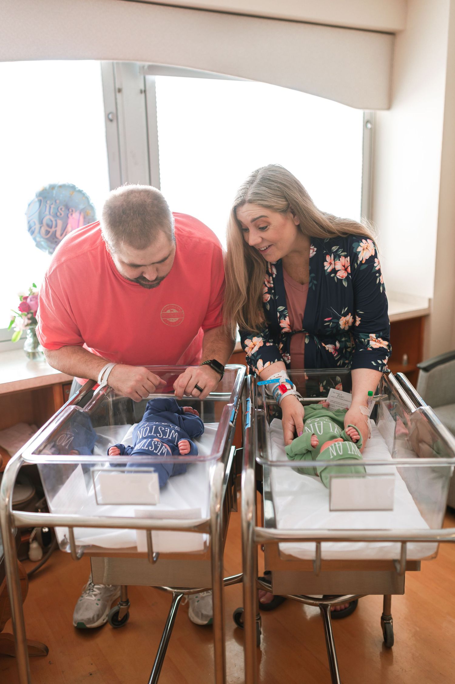 Family members looking down at newborns in hospital nursery bassinets. Knoxville Newborn Photographer UT Medical Center