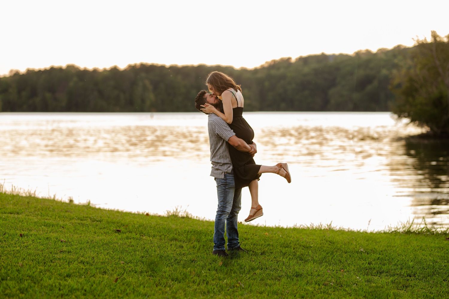Silhouetted couple embracing by a lake during sunset. Knoxville Couple Photographer. Melton Hills Park