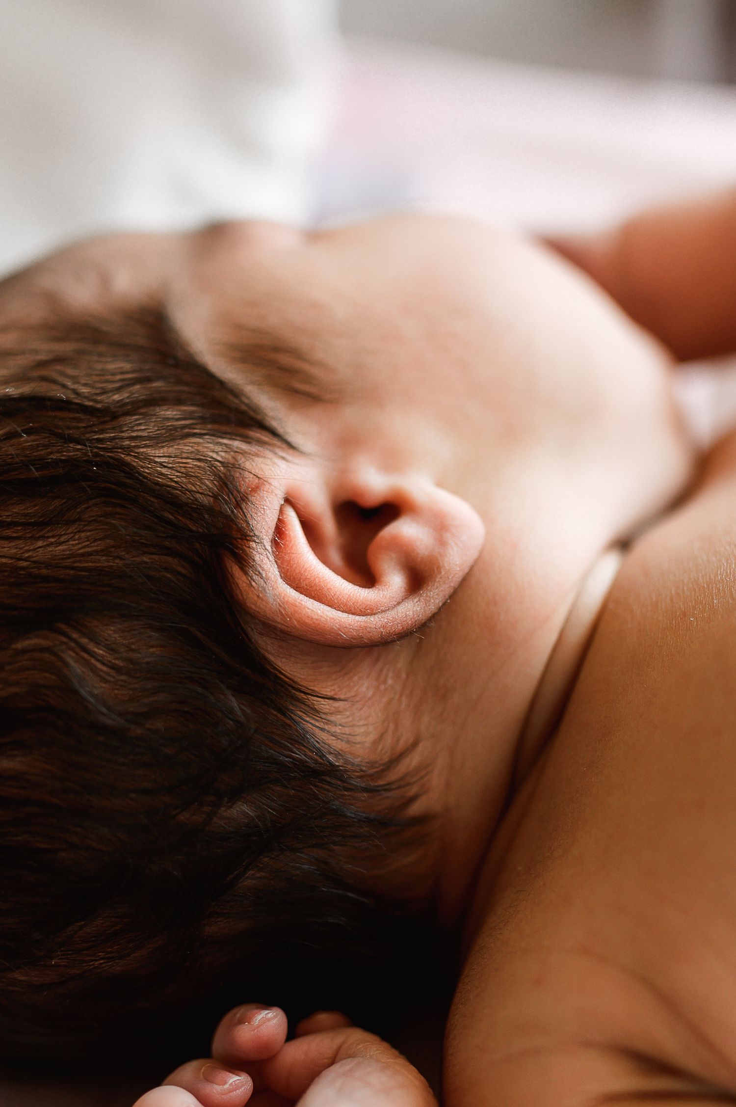 Close-up profile view of sleeping newborn with dark hair. Knoxville Newborn Photographer