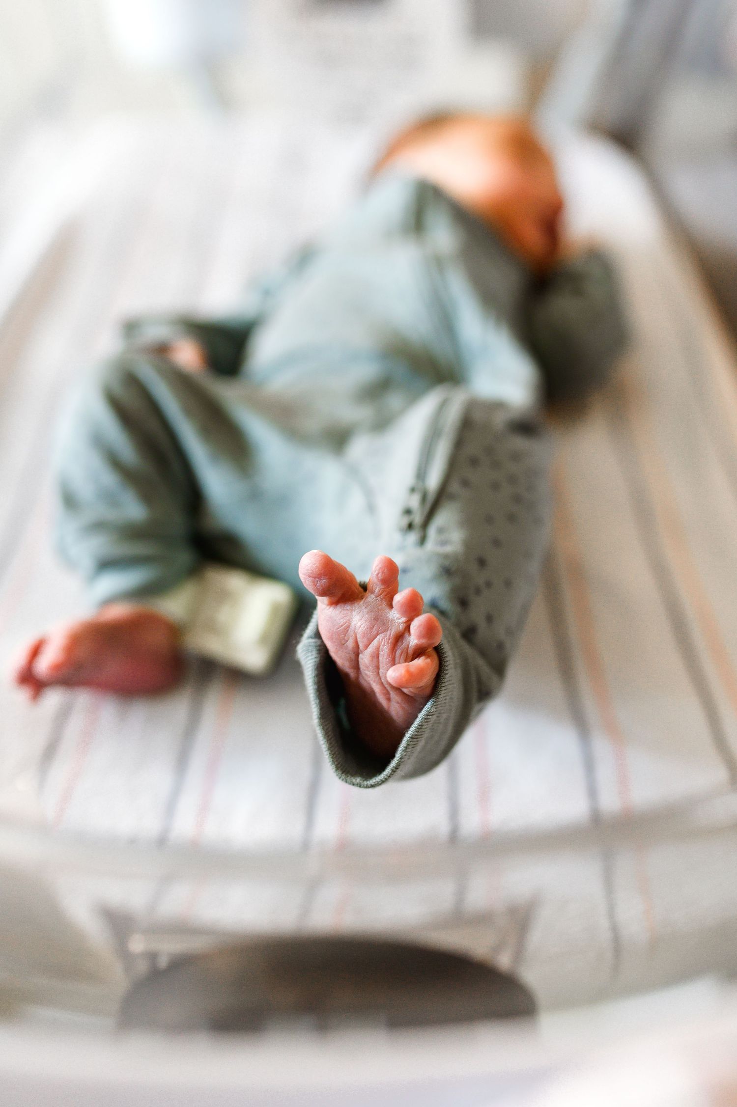 Small hands and feet visible against a white surface wearing light blue clothing. Knoxville Newborn Photographer UT Medical Center