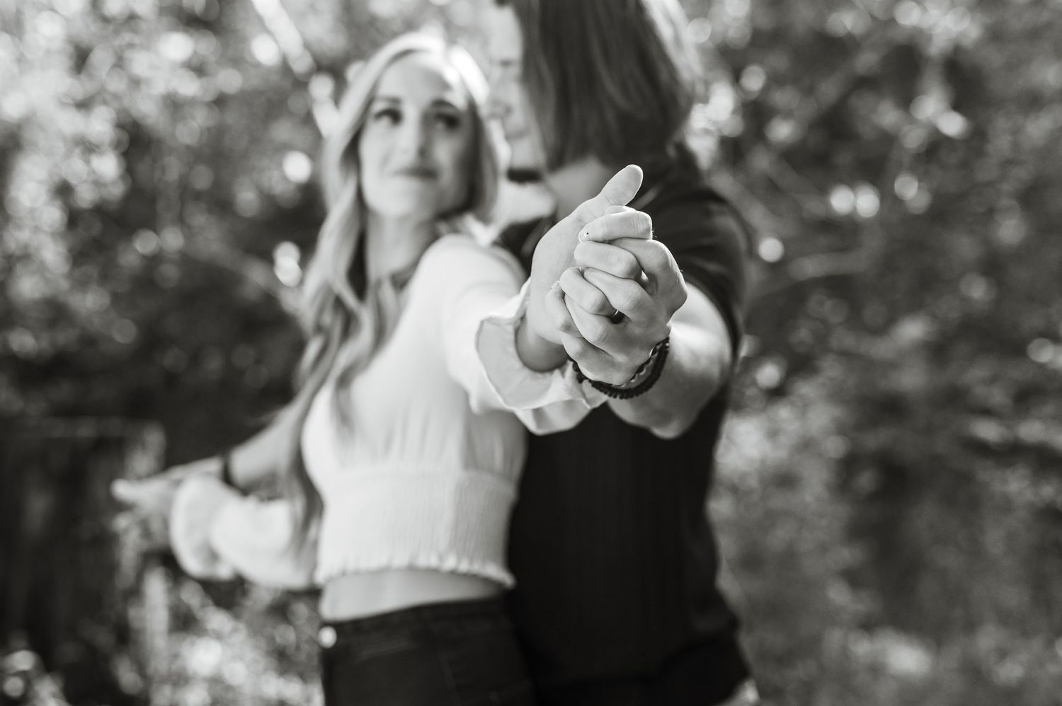 A couple dances together in an artistic black and white photo on a forest path. Knoxville Couple Photographer