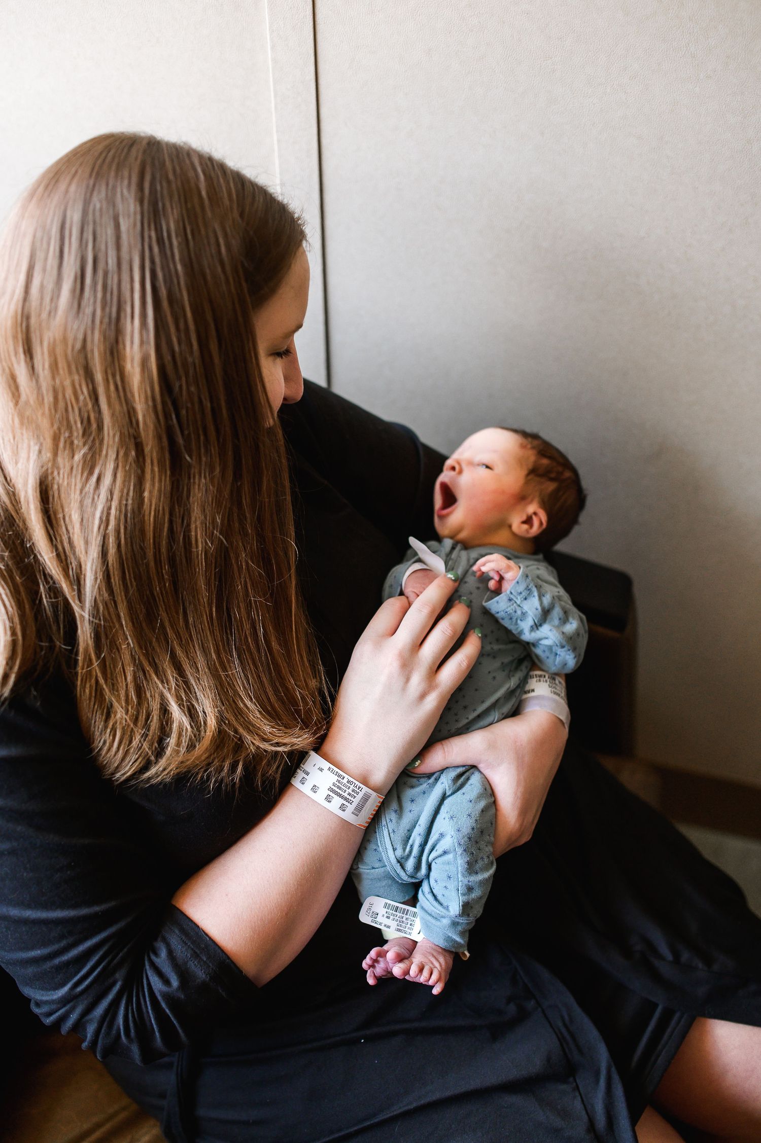 Person in black shirt holding and comforting small infant. Knoxville Newborn Photographer UT Medical Center