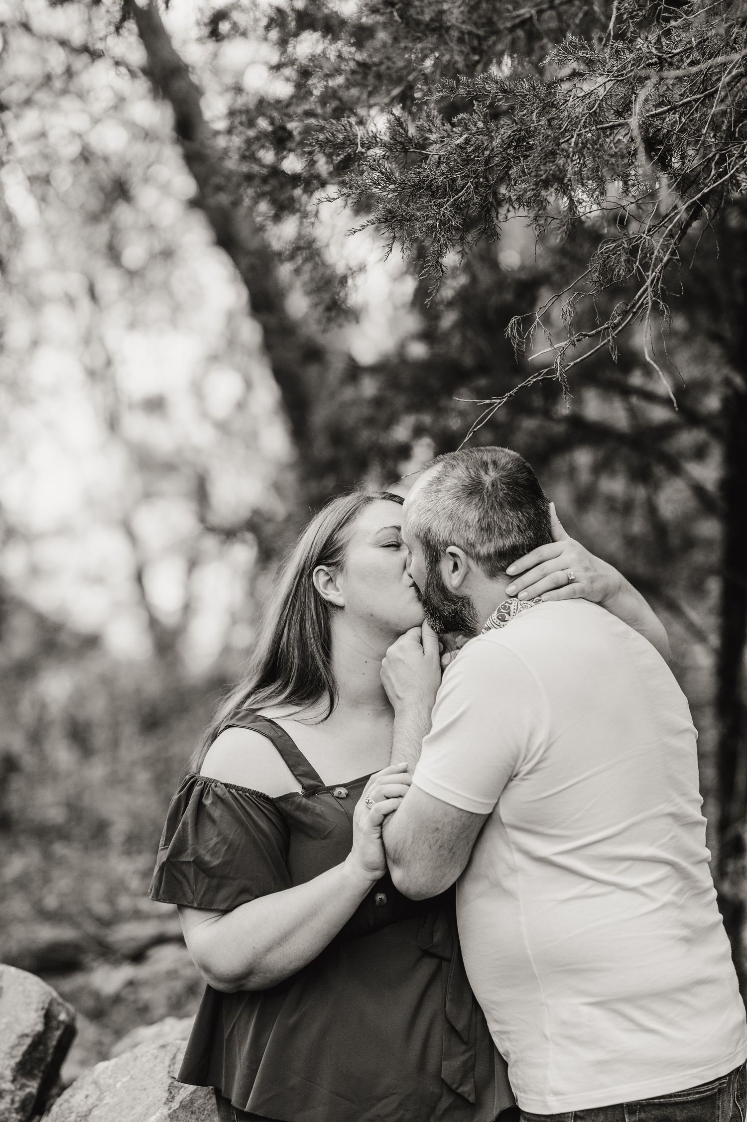 A romantic couple sharing intimate moments in a black and white outdoor photoshoot series. Knoxville Couple Photographer