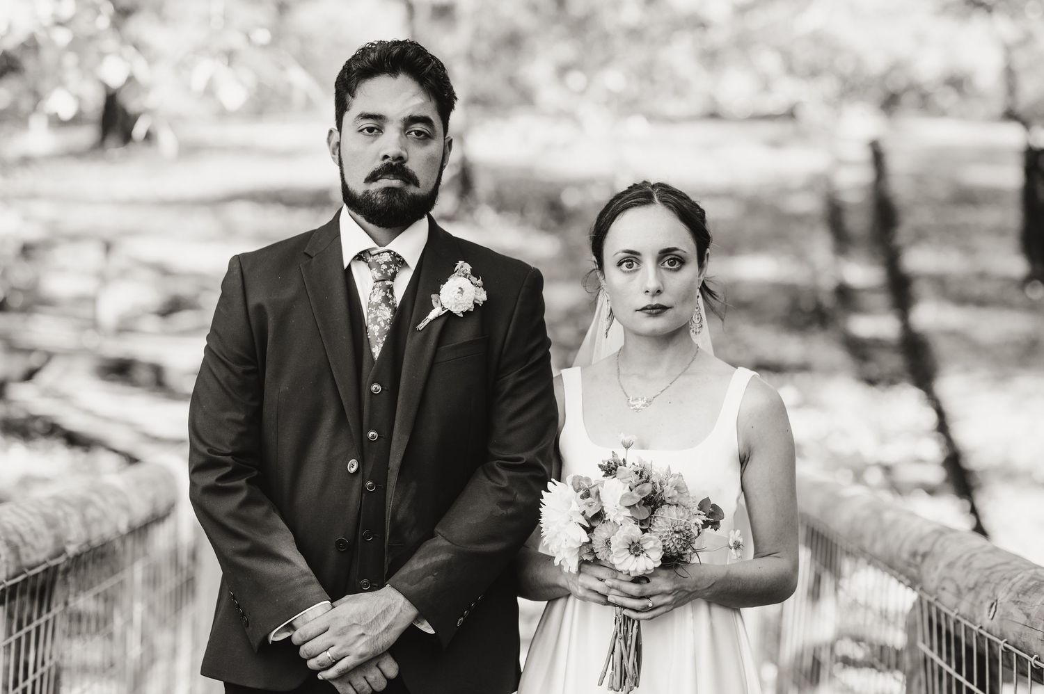 A black and white portrait of newlyweds standing together on a rustic bridge. Knoxville Wedding Photographer