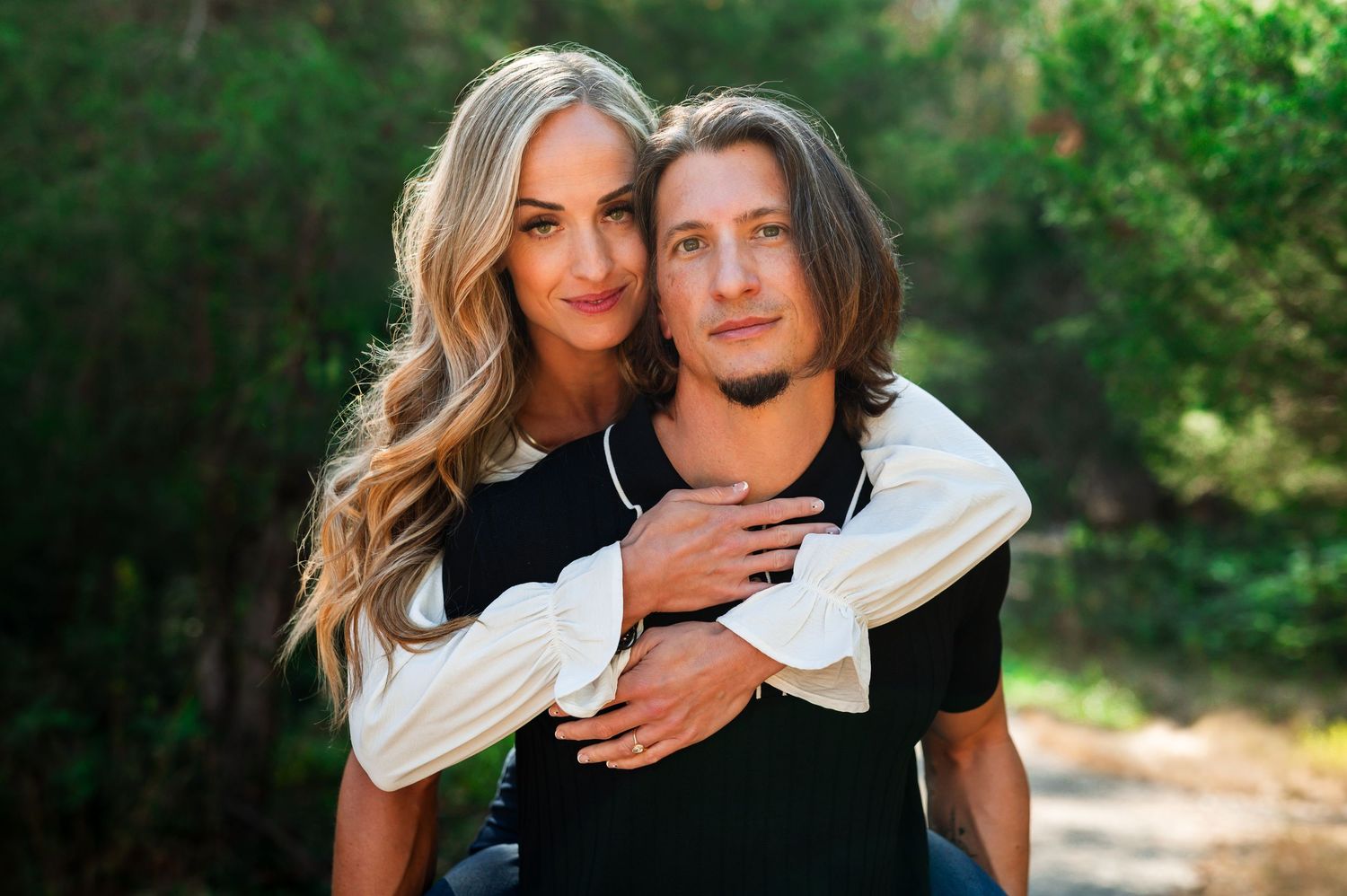 A couple embraces while wearing contrasting black and white outfits against a natural outdoor background. Knoxville Couple Photographer