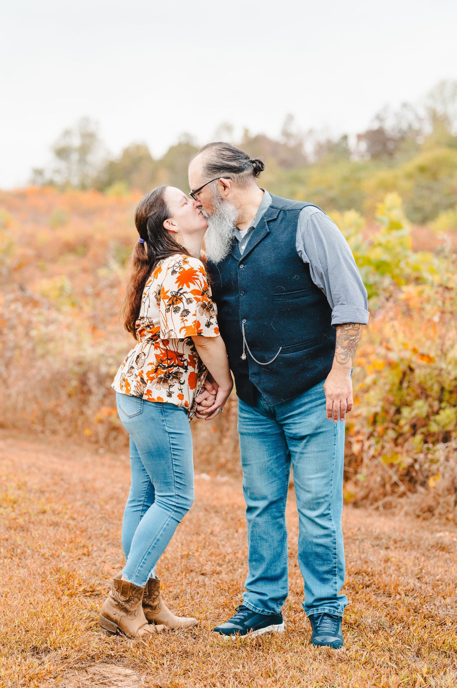 A couple shares a tender moment in a field during golden hour. Knoxville Couple Photographer. Melton Hills Park