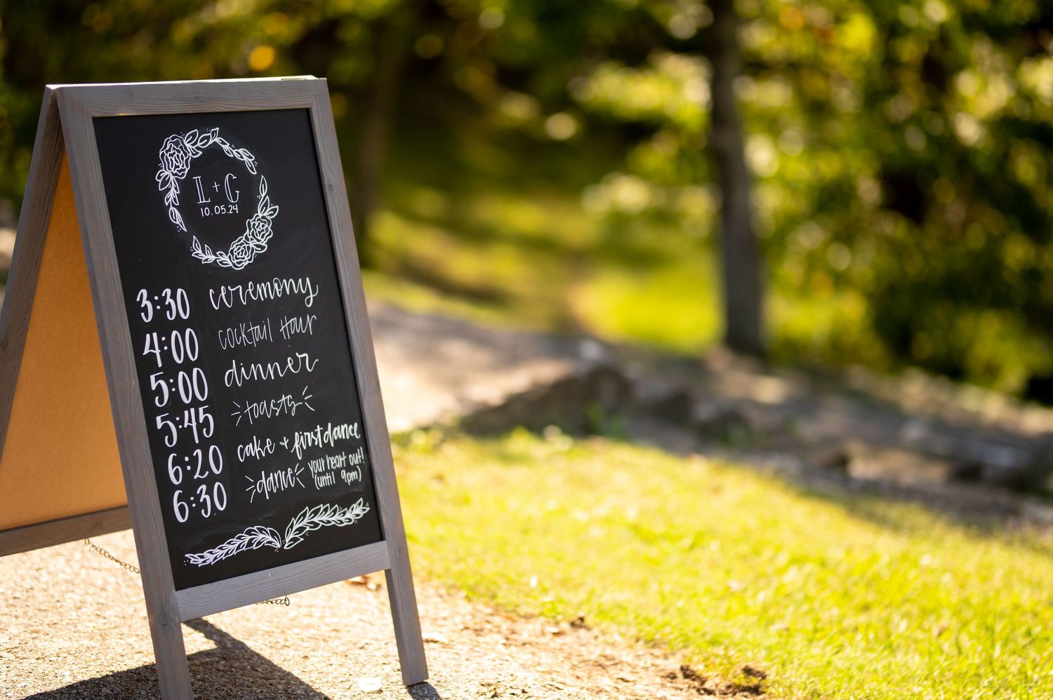 Chalkboard wedding timeline signs displayed outdoors against blurred natural background. Knoxville Wedding Photographer