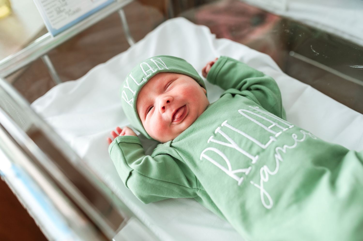 Newborn wearing mint green outfit sleeping in hospital bassinet. Knoxville Newborn Photographer UT Medical Center
