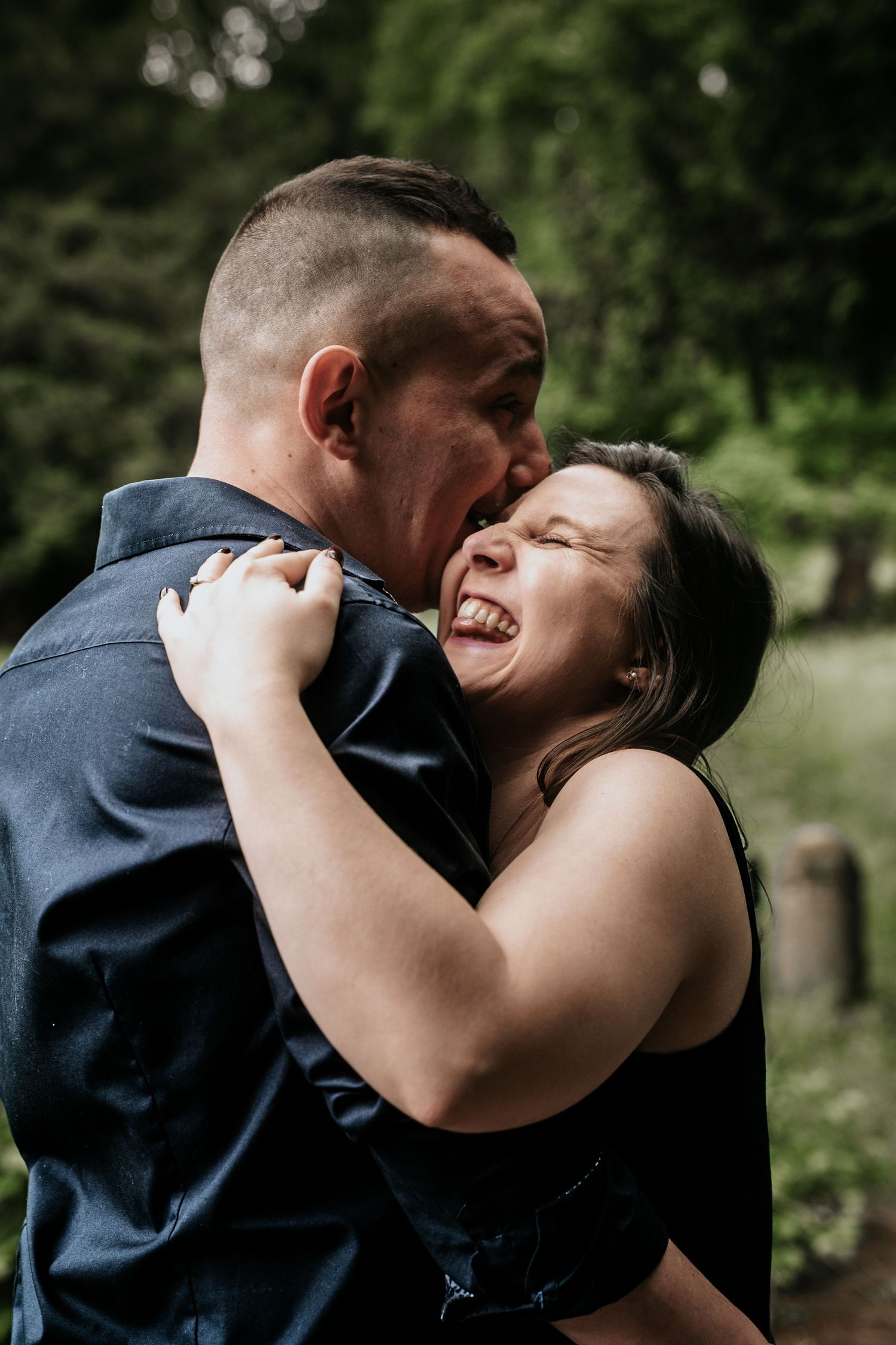 Un moment franc de joie et de rire entre un couple dans un cadre extérieur naturel.