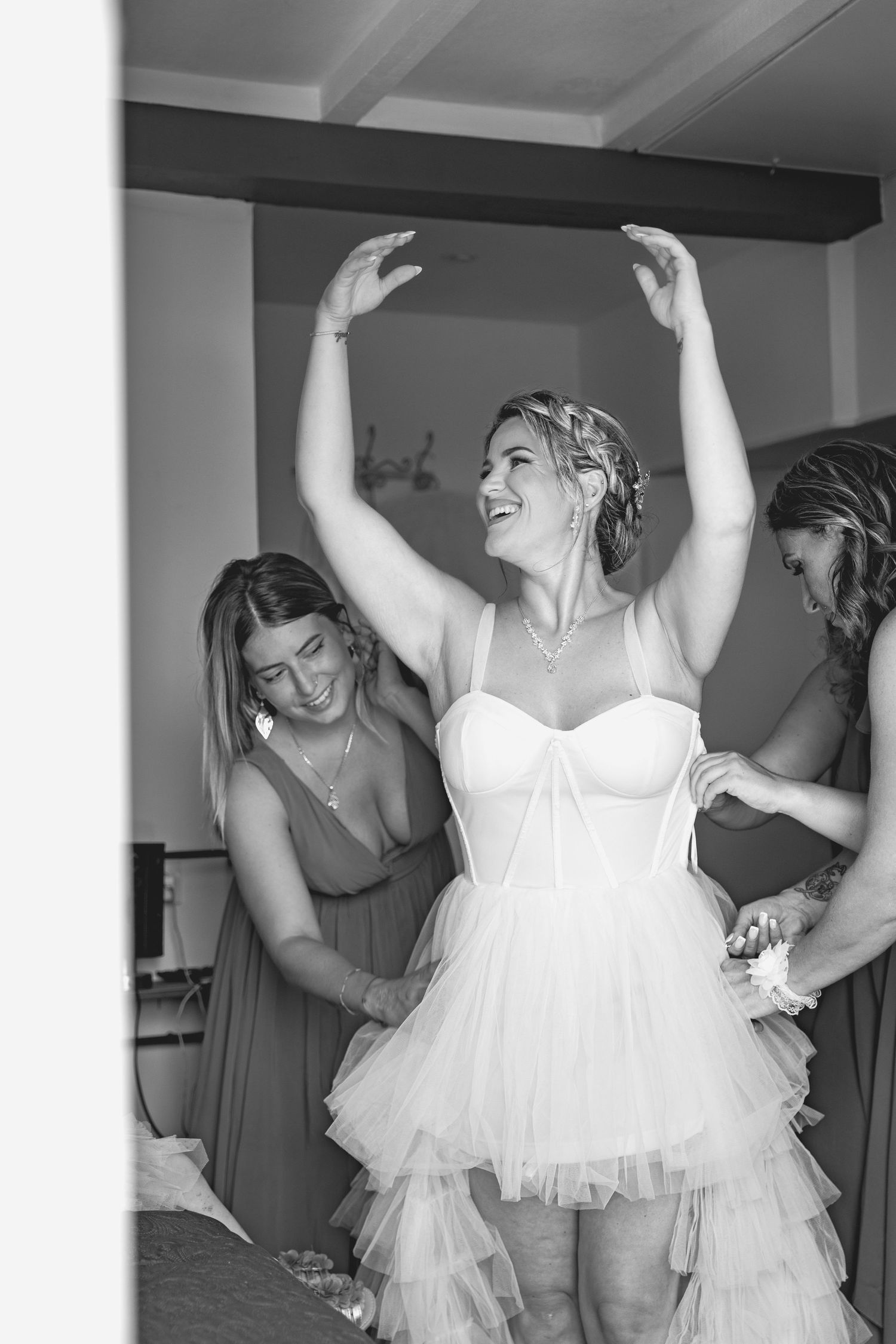 Une marié en train de se préparer pour enfiler sa robe de mariage